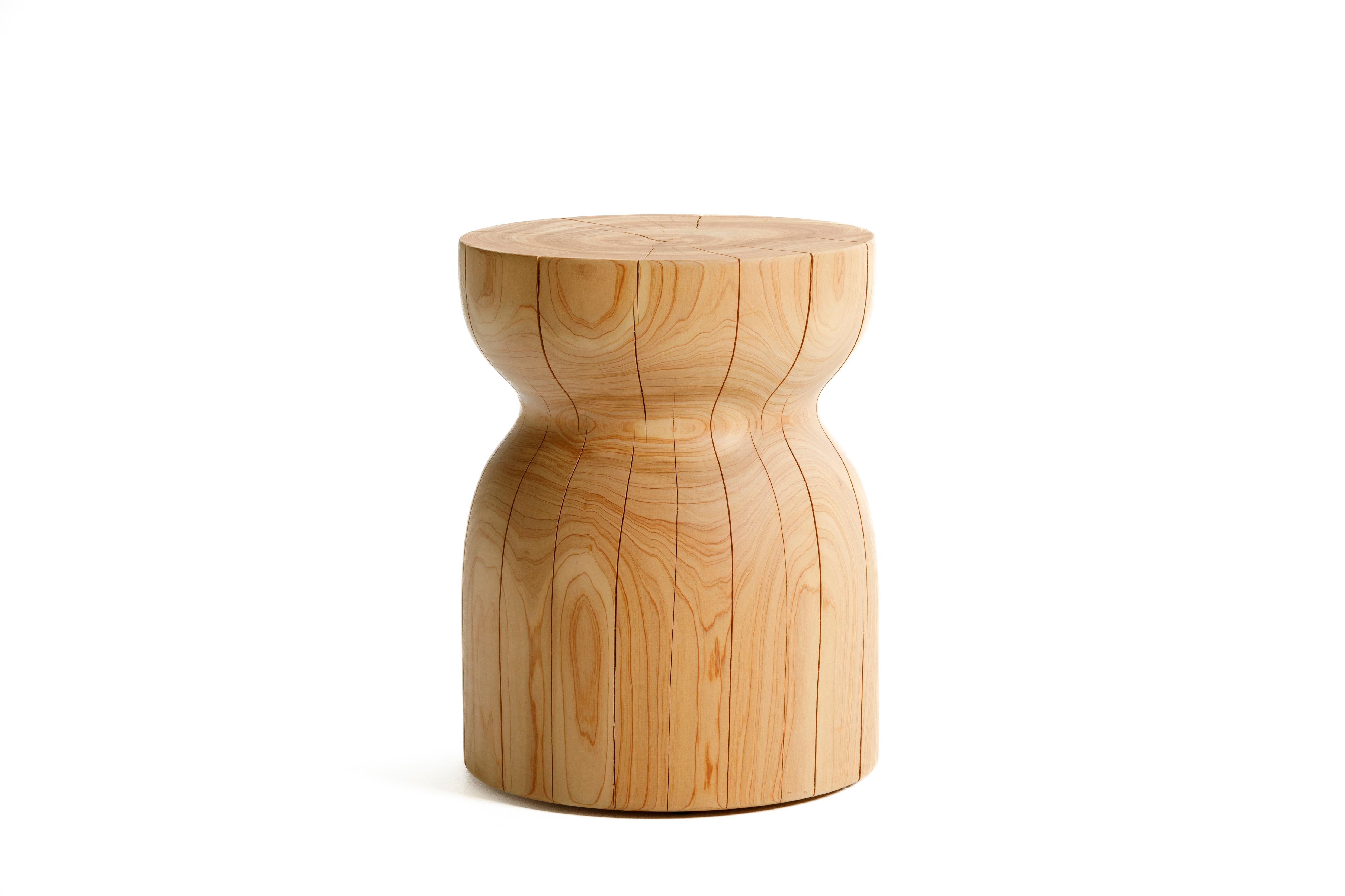 La table d'appoint Emerge est une table d'appoint sculpturale, moderne et organique, fabriquée à partir d'un bloc massif de macrocarpa (cyprès de Monterey). Le bois est fini avec un frottement à la main, à faible V.I.C., avec des huiles végétales