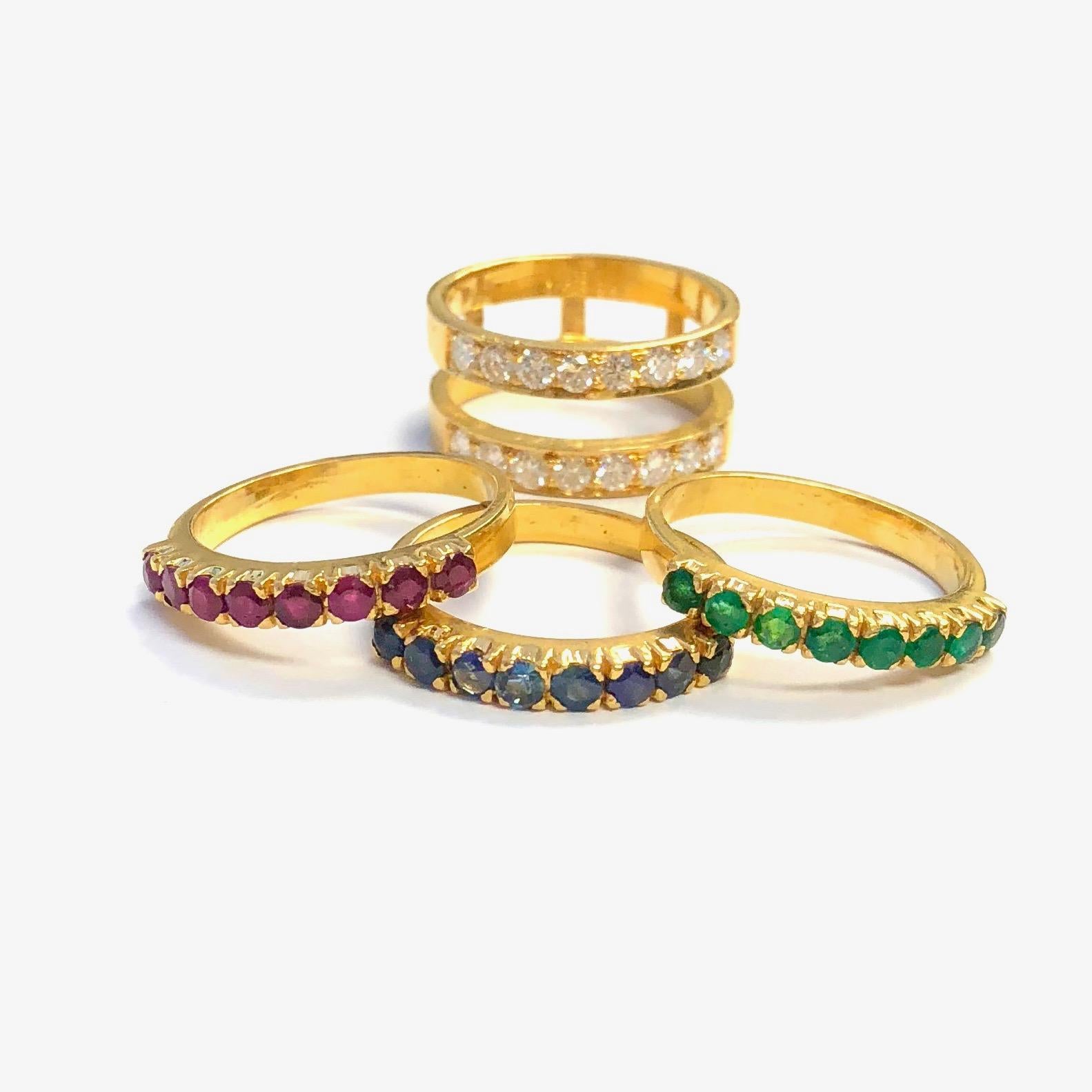 Crafted in 22K gold the set includes 3 colored stone bands and a diamond set ring guard. Each band is set with eight round cut stones, one emerald, one ruby and one sapphire ring. The ring guard is set with sixteen round brilliant cut diamonds,