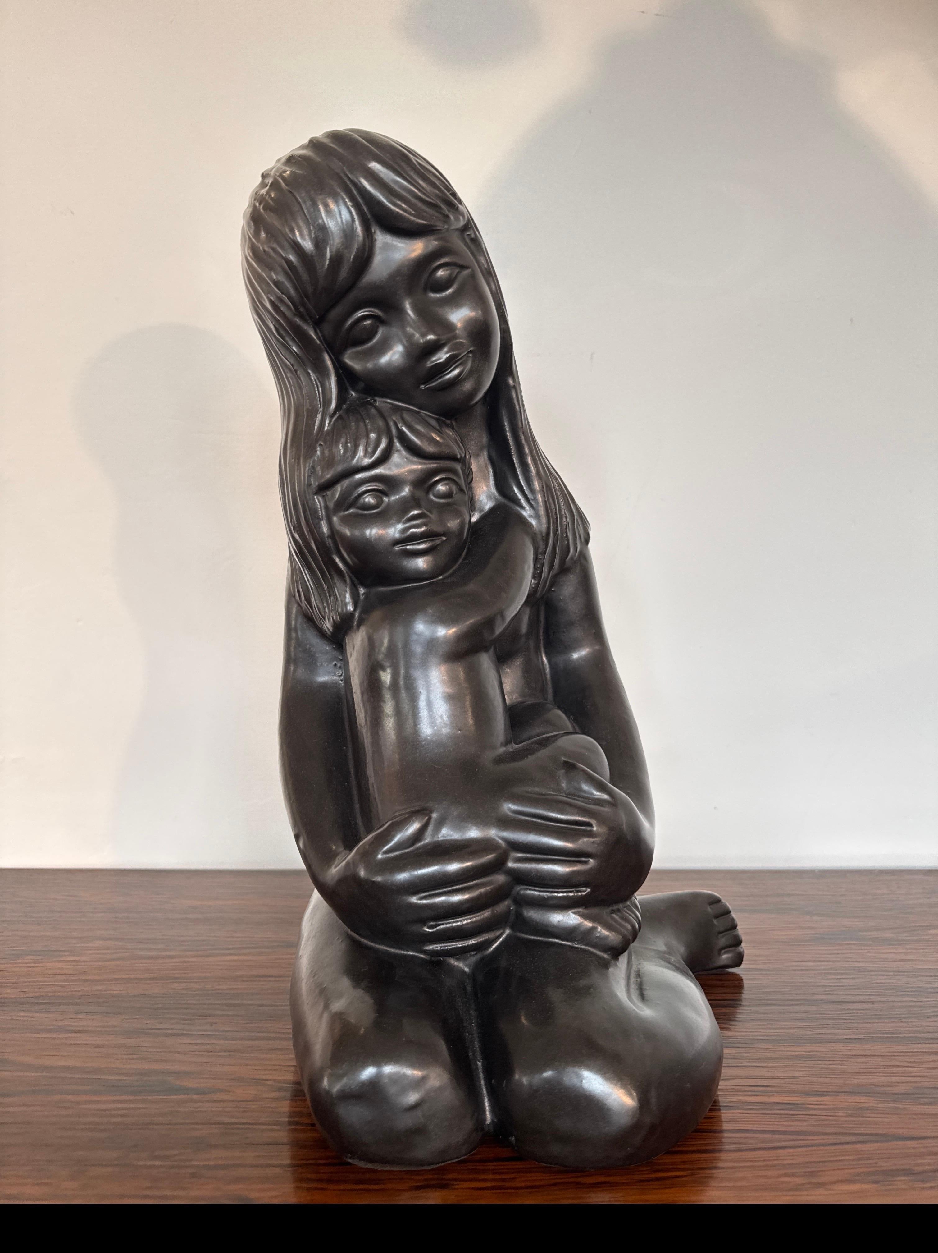 Statue einer sitzenden Mutter mit Kind von Emiel Laskaris, St. Niklaas Belgien ca. 1960.  Schwarze Metallic-Satin-Glasur auf rötlich-braunem Ton. Sehr anschaulich und auffallend kraftvoll im Erscheinungsbild. Schöne Formen und Details. 

Eine gute