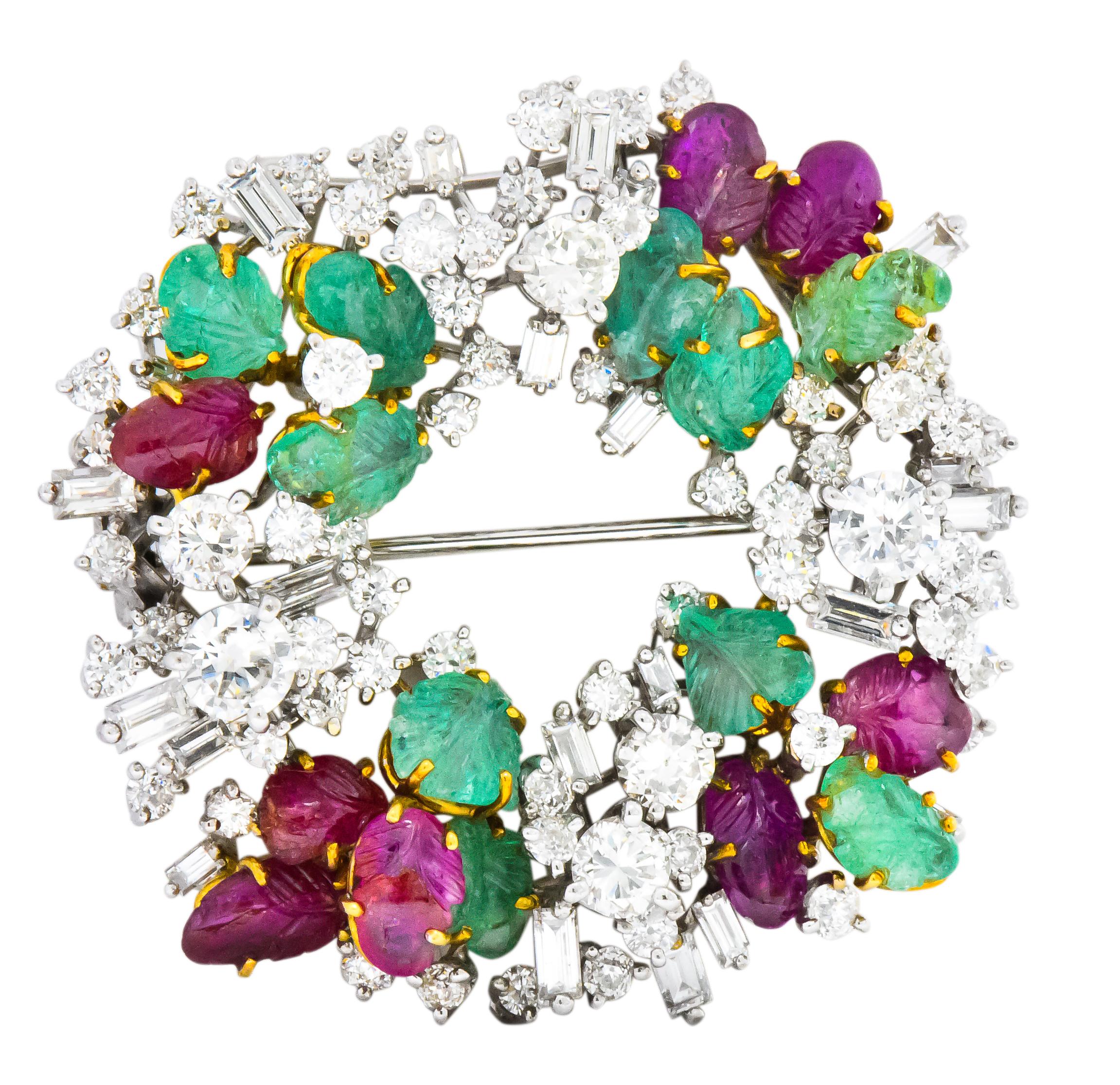 Brooch designed as wreath with round brilliant and straight baguette cut diamonds, weighing approximately 4.25 carats total, GHI color and VS to SI clarity

Accented with foliate motif carved rubies and emeralds, weighing approximately 3.50 carats