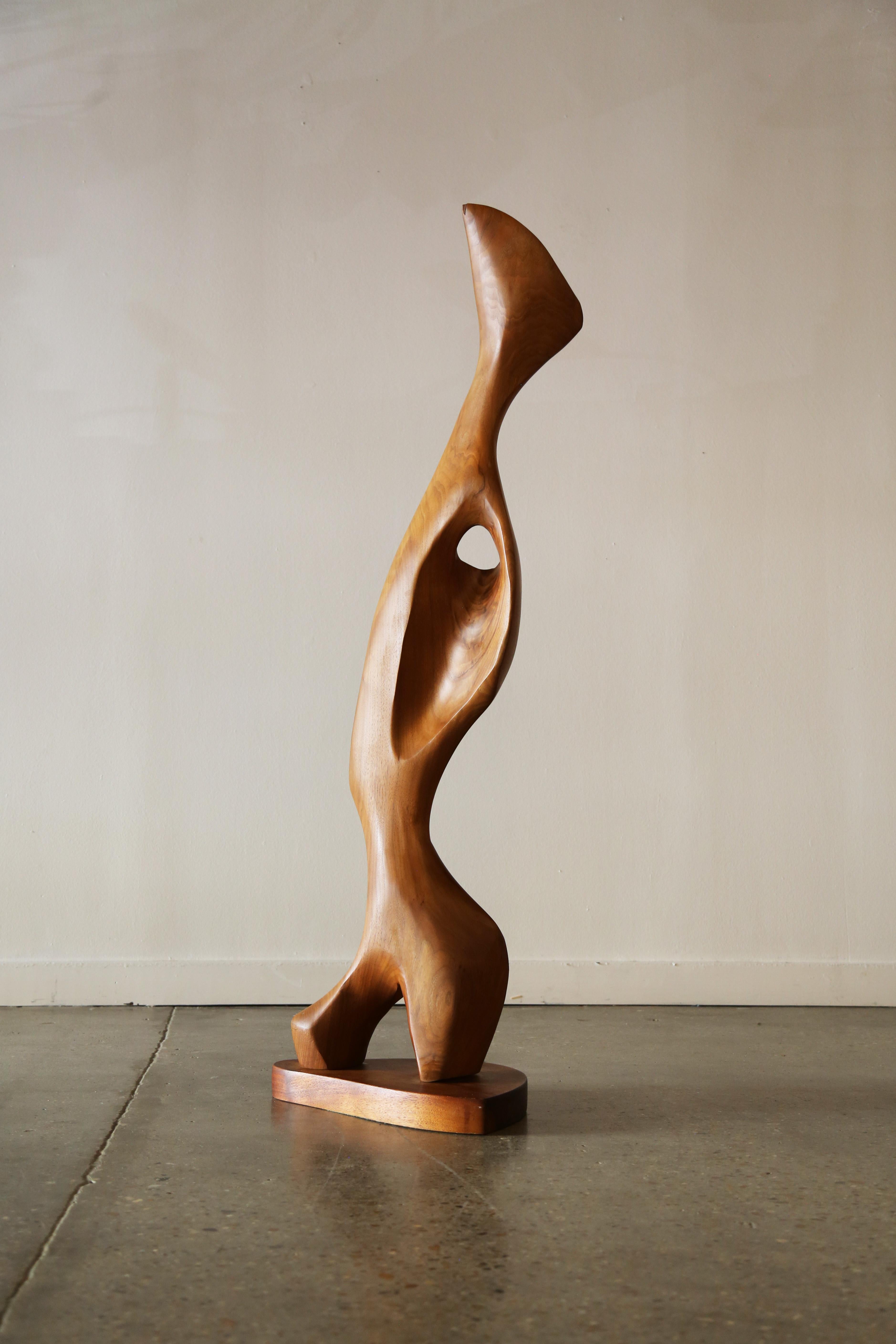 Large scale free standing sculpture hand carved by Emil Milan. Executed in walnut, the flowing sculpture makes way to voids which gives it a light and moving appearance. Chiseled recesses draw your eye to the top. A great piece from the master wood
