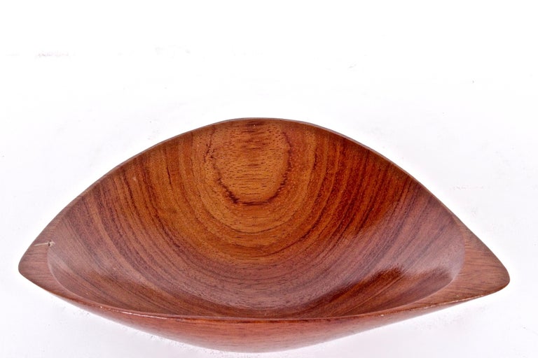 American Mid-Century Hand crafted Sculpted  Small African Rosewood Bowl by Emil Milan.  Featuring a smooth triangular free form. Organic. Examples of Emil Milan’s work reside in the Smithsonian American Art Museum. SIgned Emilan Bubinga on base.
  