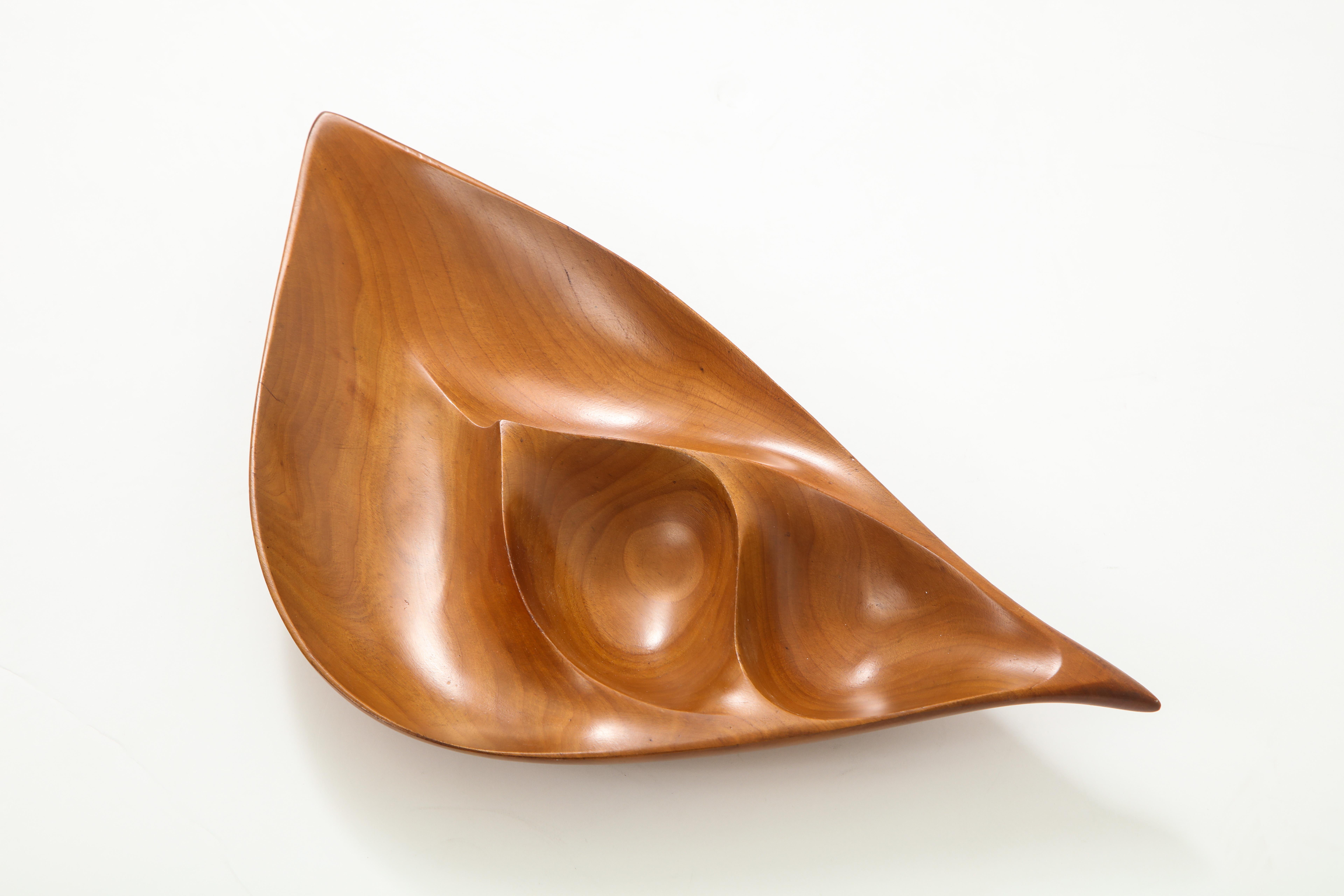 Finely carved, freeform segmented dish in cherry wood, created circa 1960s, by esteemed midcentury woodworker Emil Milan (1922-85). Trained at the Arts Students League of New York, Milan worked in the metropolitan New York area until relocating to