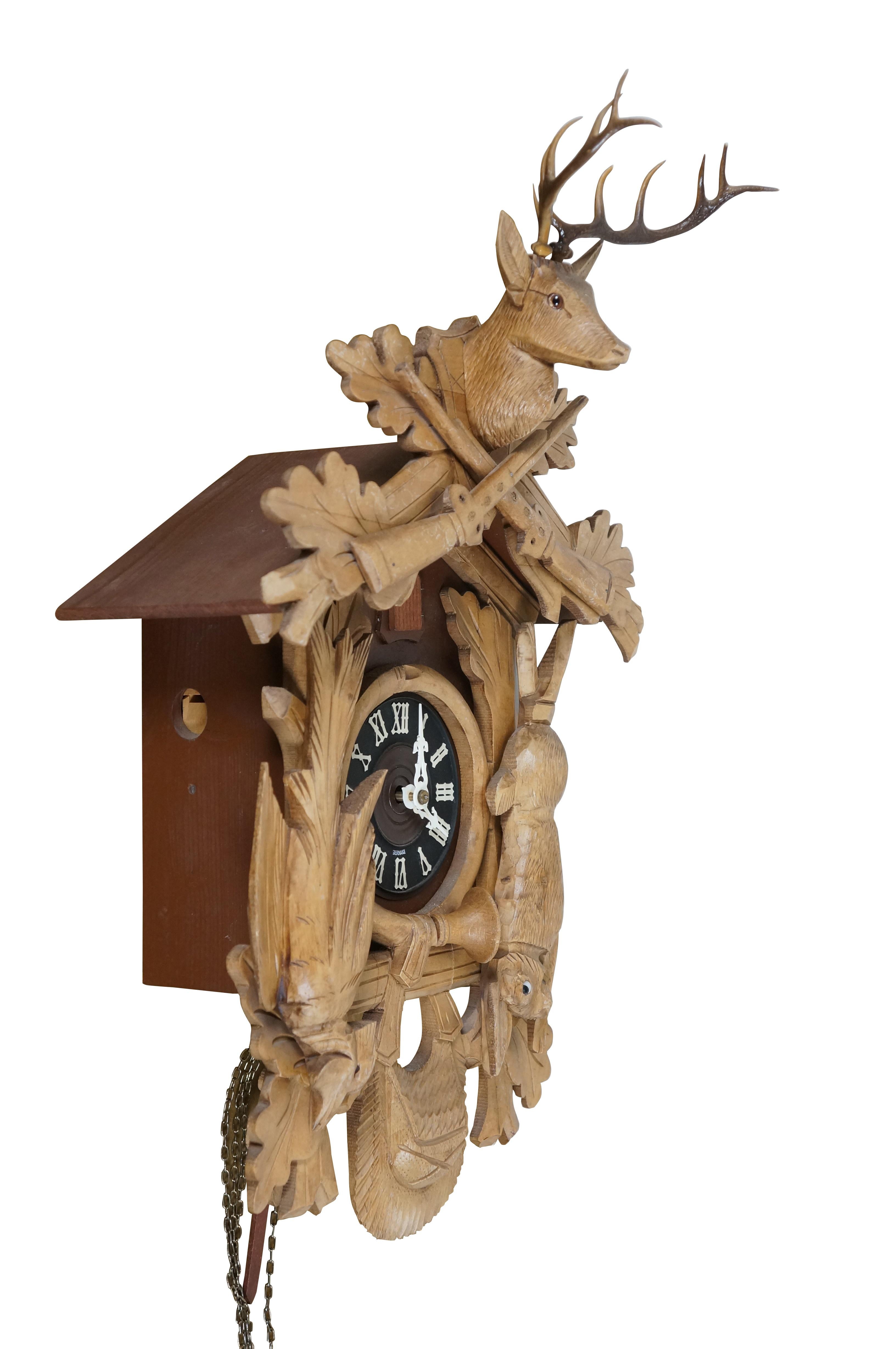 Vintage 1970s Wandbehang, 8 Tage, läutende Kuckucksuhr. Wird Schmeckenbecher zugeschrieben.  Aus Holz geschnitztes Schwarzwaldjäger-Motiv mit Eichenlaub, Gewehren, Horn, Jagdtasche und Wild (Kaninchen und Fasan), gekrönt von einem Hirschkopf mit