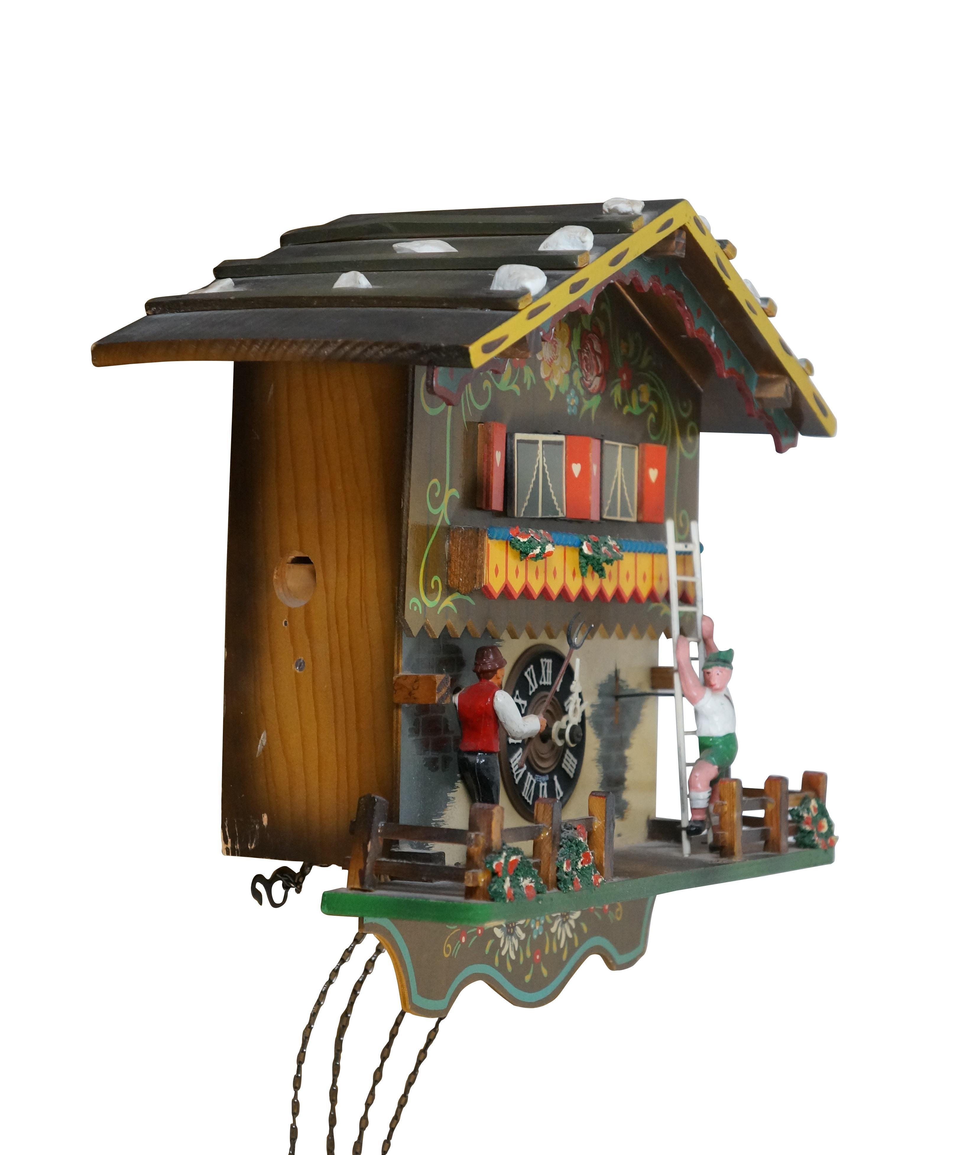 Vintage mid 20th century wall hanging 8 day, chiming / musical cuckoo clock by Emil Schmeckenbecher. Wooden house/chalet shaped case hand painted with Black Forest / Bavarian folk art decoration. Hand painted plastic figures depict a young man in