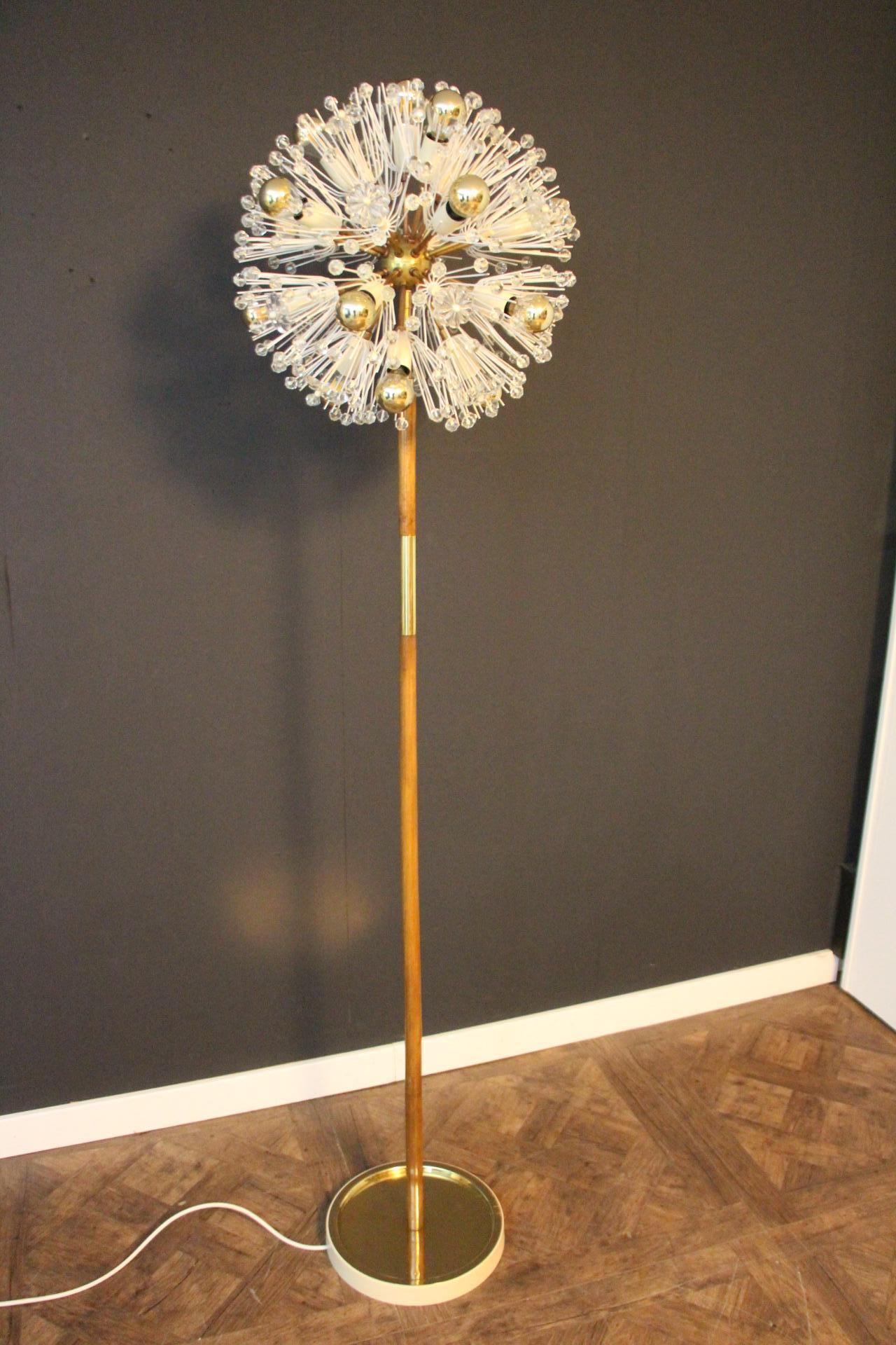 This spectacular Sputnik floor lamp looks like a flowers explosion.It features a multitude of brass rods ending with bulbs or clear crystal flowers. Each rod is directly fixed on its polished brass central sphere . Its rods are ending with delicate