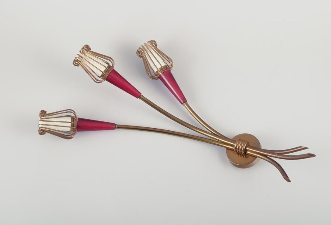 Emil Stejnar, Austrian designer, for Rupert Nikoll. 
A pair of Art Deco wall lamps in brass and burgundy acrylic plastic.
Approximately from the 1940s.
In perfect condition.
Dimensions: H 48.0 cm x W 27.0 cm.