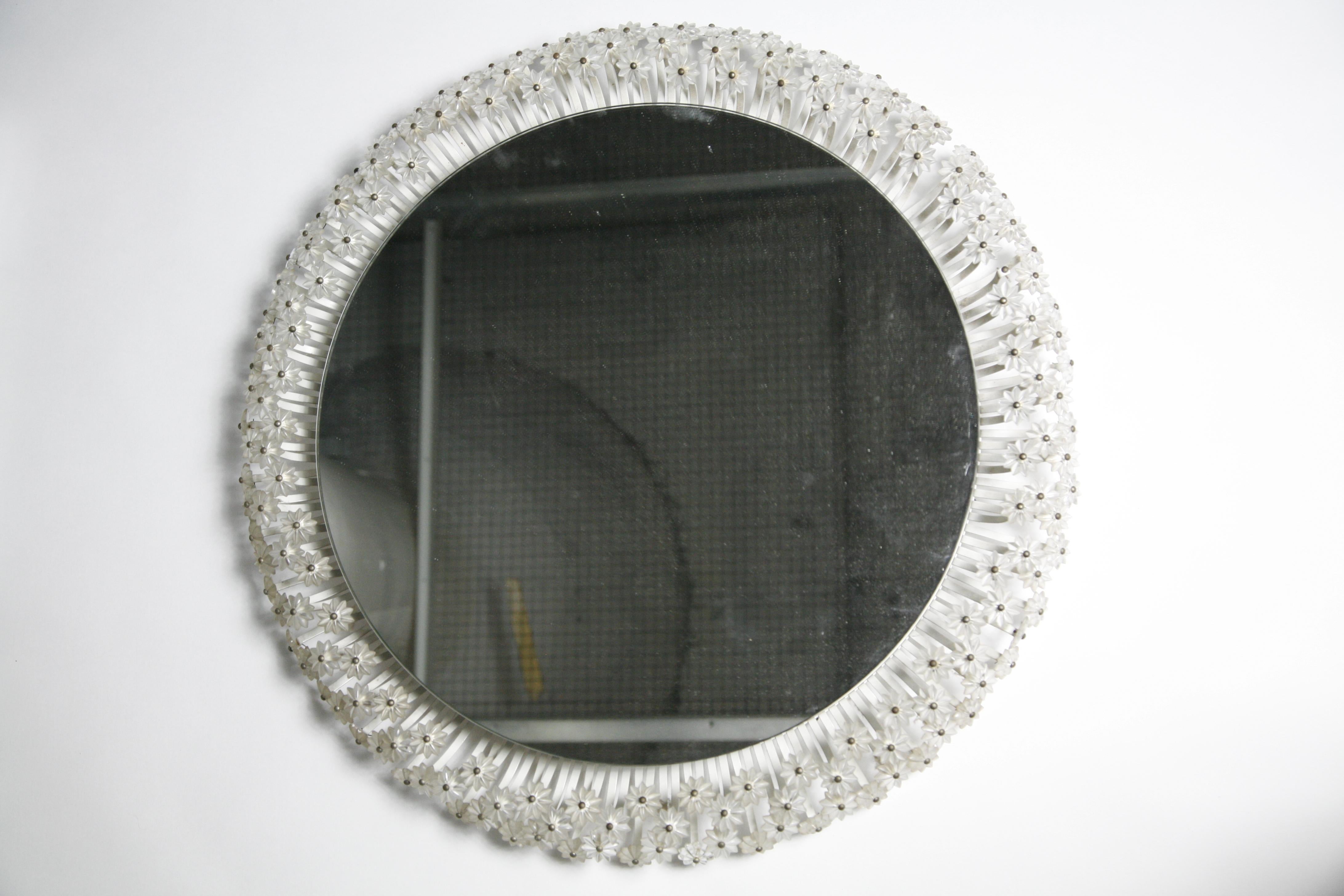 Emil Stejnar round mirror surrounded by numerous glass flowers on a frame that is white painted, lid up behind the mirror illuminates the tiny glass flowers surrounding the mirror.

Can be rewired upon request.