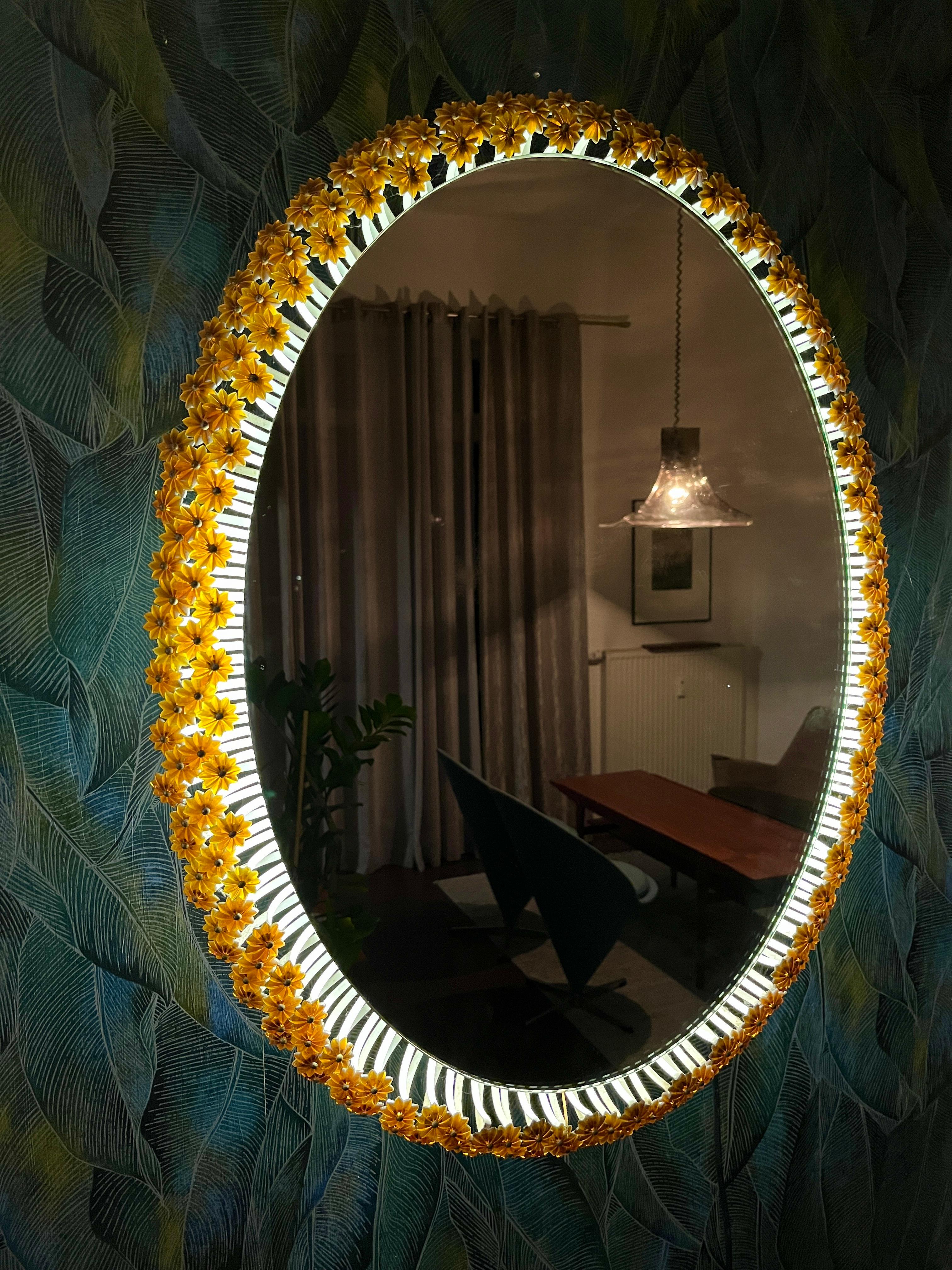 Miroir mural rond de Münchner Zier-Form, conçu par Emil Stejnar, avec éclairage indirect et fleurs en plastique des années 1960.

Le miroir peut être suspendu verticalement ou horizontalement.
Cet article vintage est entièrement fonctionnel et en