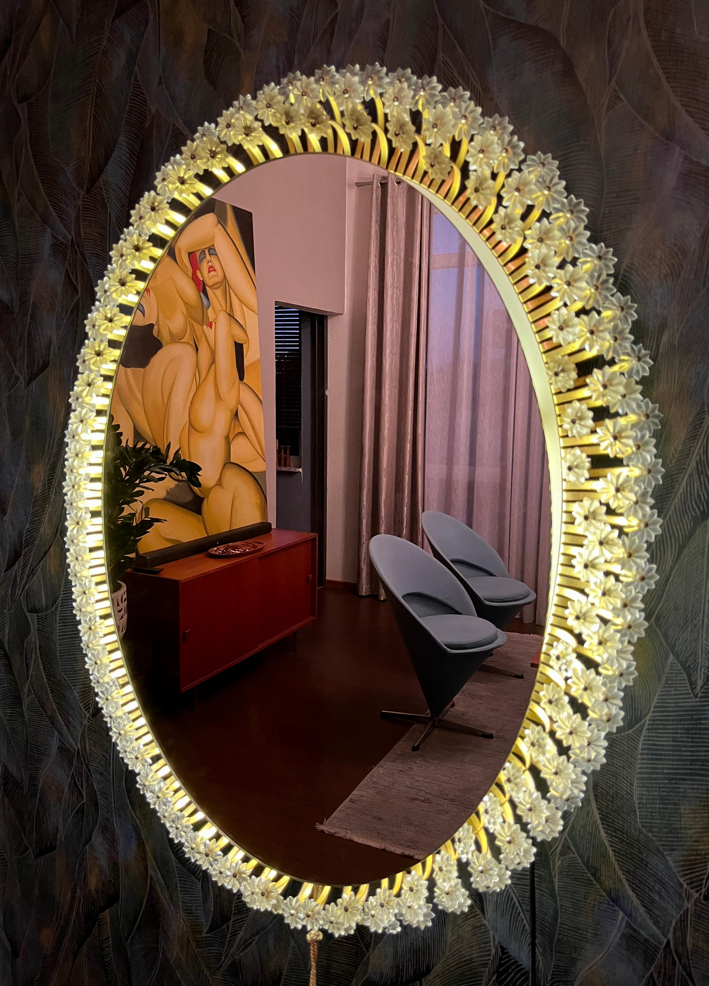 Miroir mural rond de Münchner Zier-Form, conçu par Emil Stejnar, avec éclairage indirect et fleurs en plastique des années 1960.

Le miroir peut être suspendu verticalement ou horizontalement.
Cet article vintage est entièrement fonctionnel et en