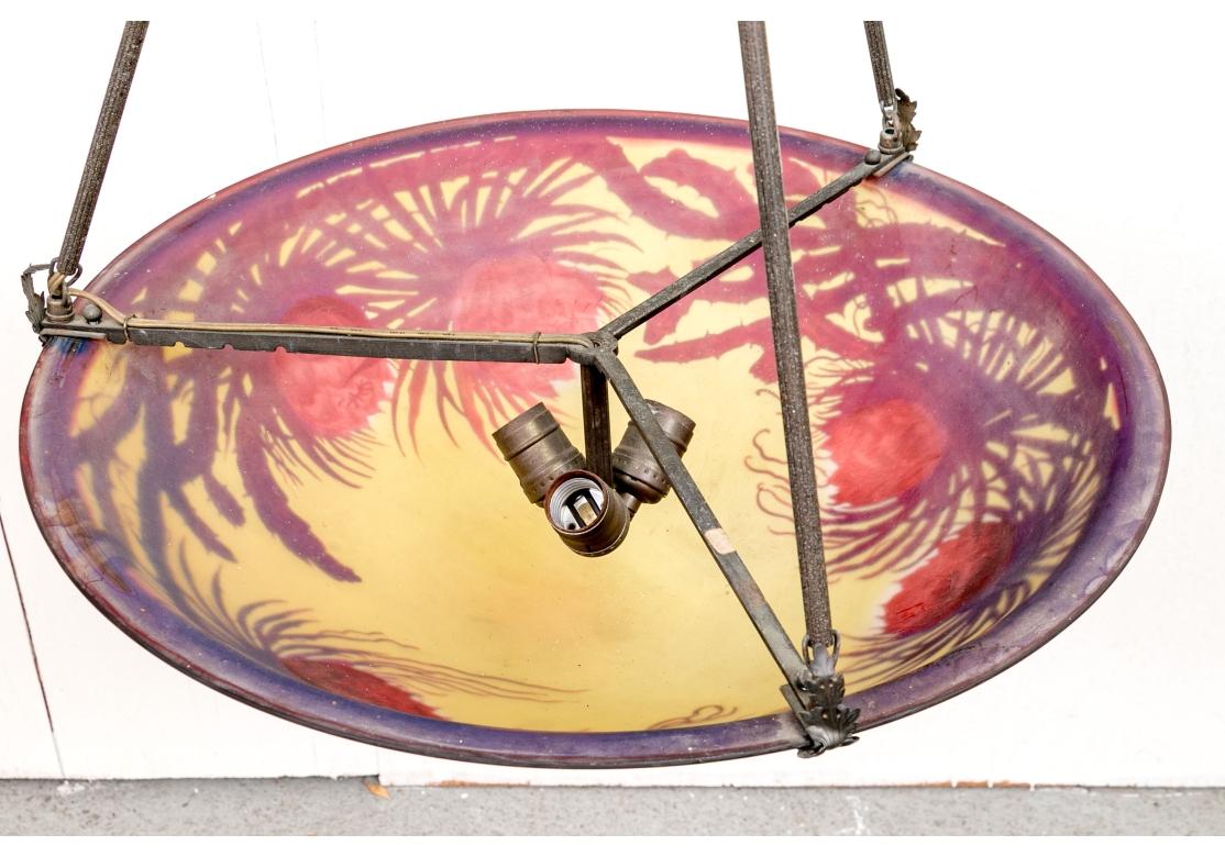 A dramatic and rare Art Nouveau acid etched multi-layered glass chandelier decorated with cactus flowers and having particularly fine color. The bowl form chandelier with engraved in acid cameo having three lights and two-part bronze rod