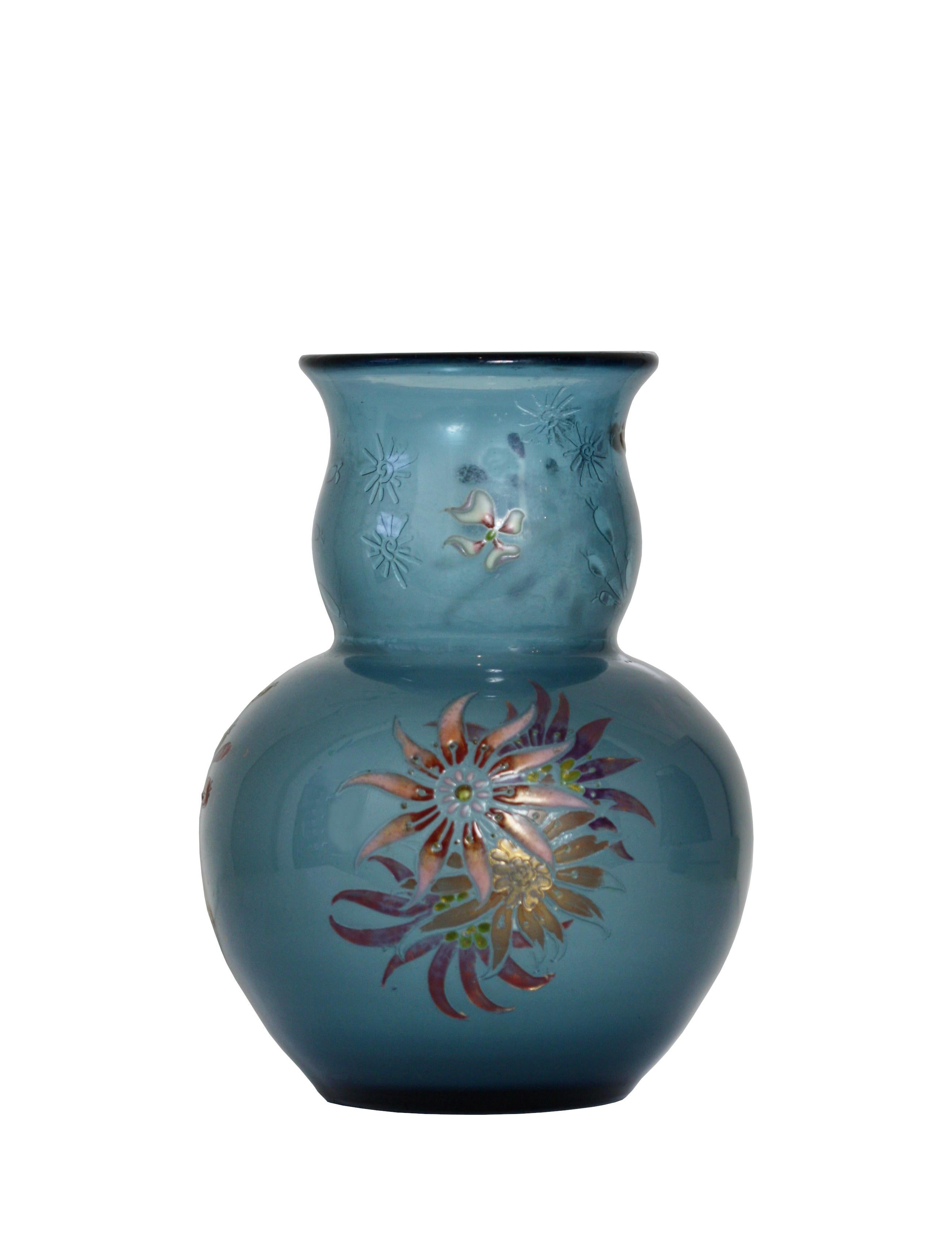 Émile GALLÉ (1846-1904),
circa 1890
The enamel decorated bulbous body with an out-turned rim of translucent to cloudy marine blue, decorated with floral sprays highlighted in gilt, the neck internally etched with dotted starbursts
Signed Galle