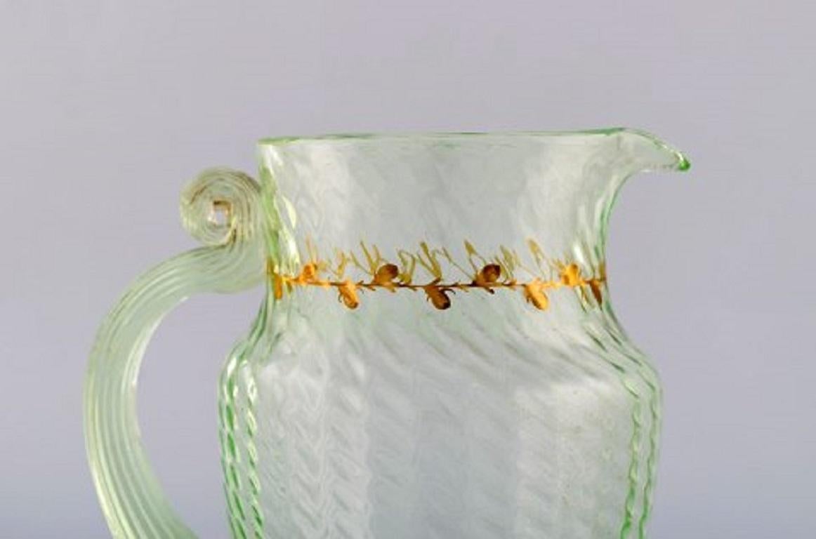 Emile Gallé (1846-1904). Early and rare jug in mouth-blown light green art glass with hand painted gold decorations in the form of leaves. Museum quality, 1870s-1880s.
Measures: 21 x 17.5 cm.
In very good condition.
Signed.