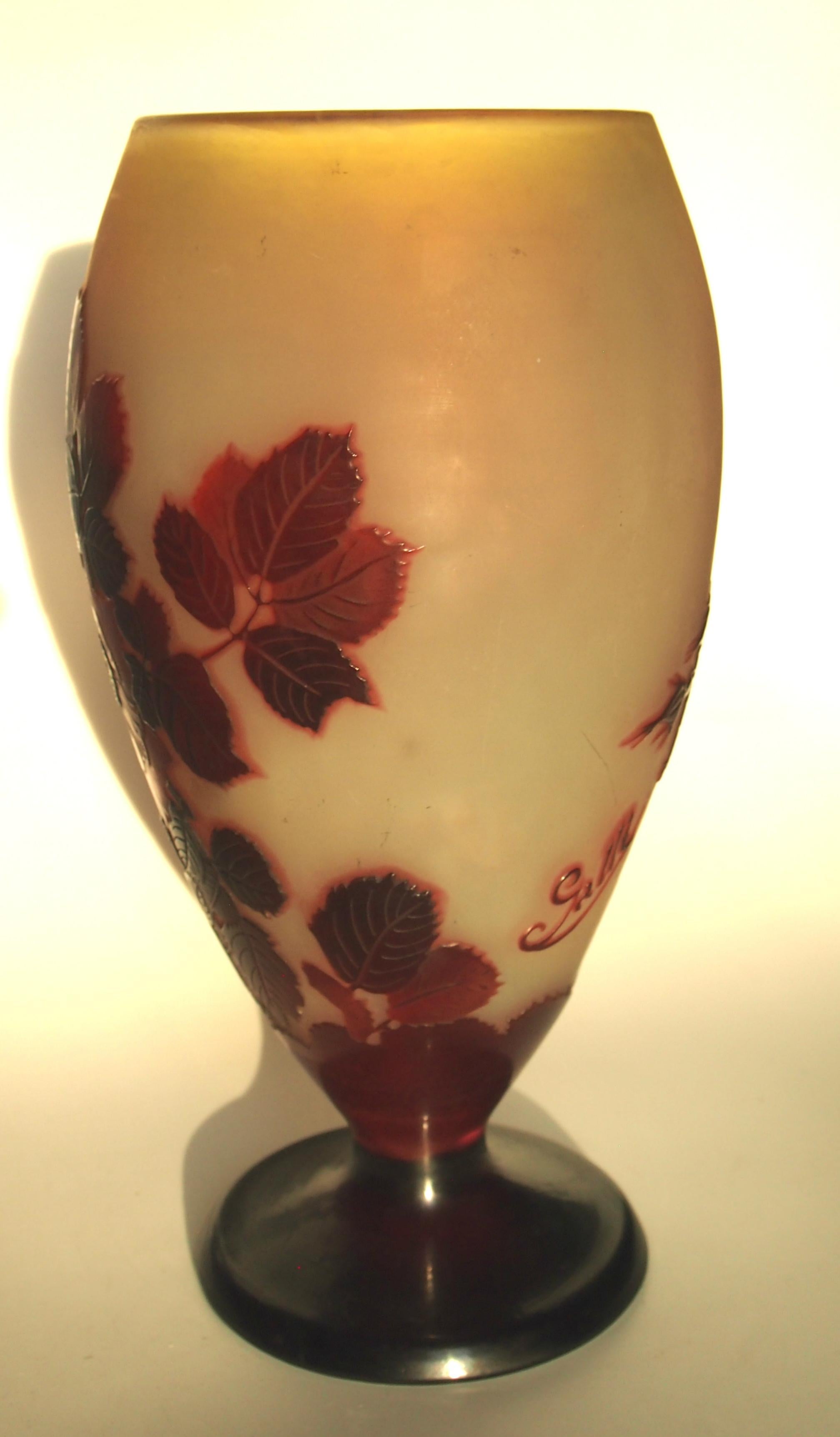 Wonderful signed Emile Galle Cameo footed vase. Reds, pinks and maroon over yellow/orange beneath. It depicts superb blooming roses. To make the roses stand out Emile Galle has polished out the inside orange layer of the vase behind the roses to