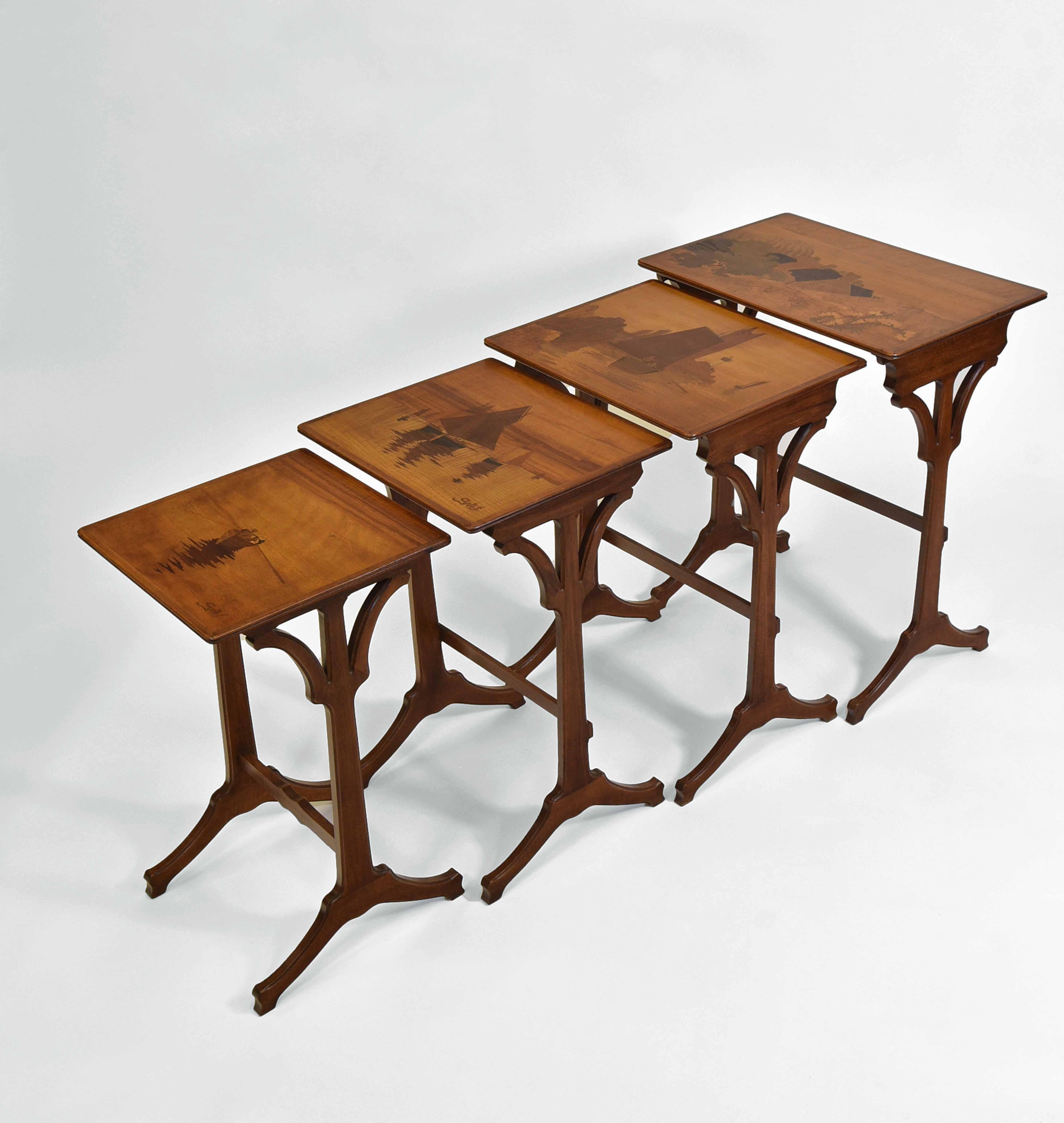 Superbe nid de tables Art Nouveau français avec des plateaux gradués, ayant des incrustations de bois spécimen avec des thèmes nautiques de la Bretagne. Chaque table est signée en marqueterie 