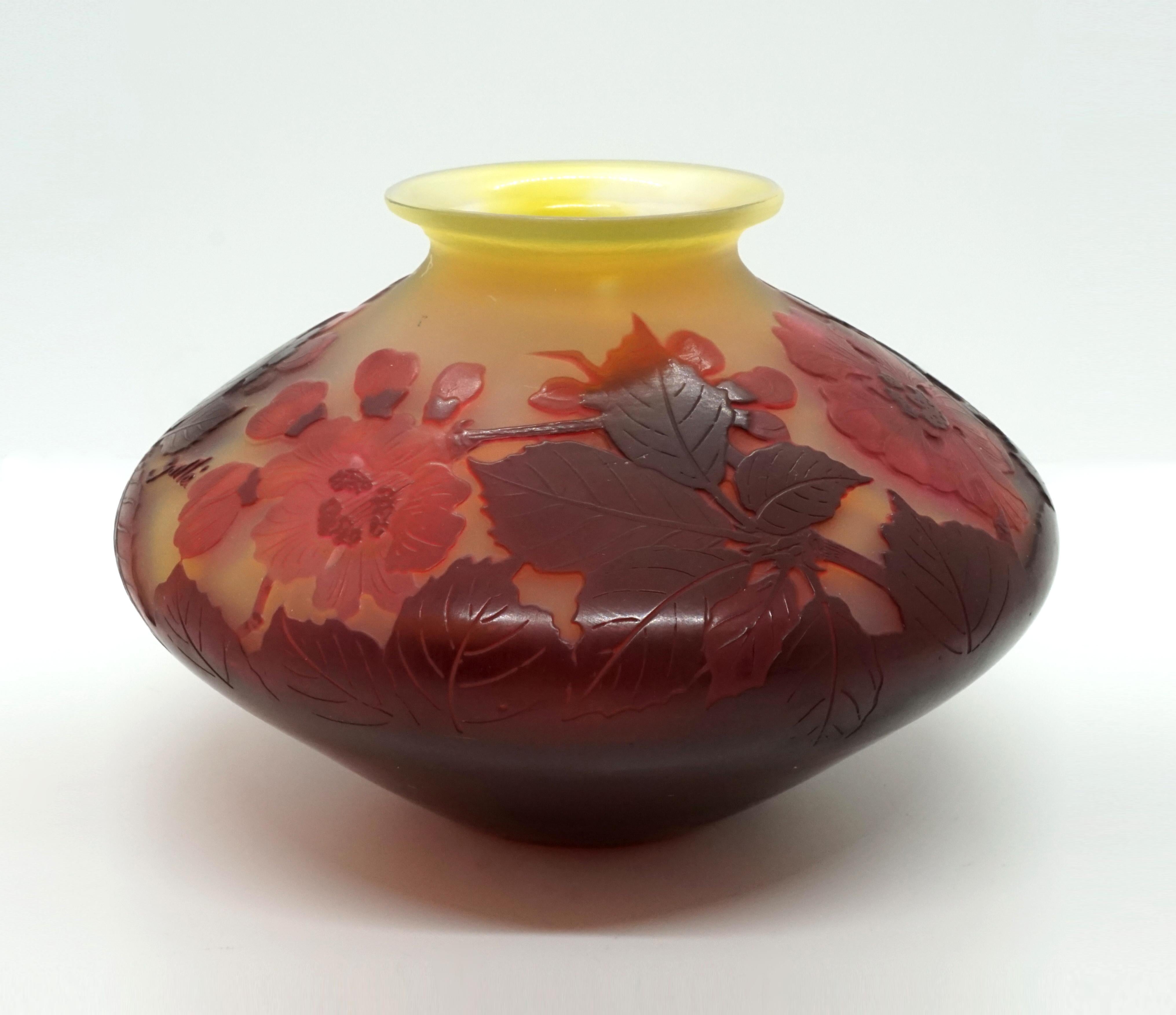 Japanese-inspired, discus-shaped vase with a short neck and a flared mouth rim. Stand on a small round floor plan without a foot. The lower half, apart from the base, is completely covered in burgundy red, the upper part is etched decor with