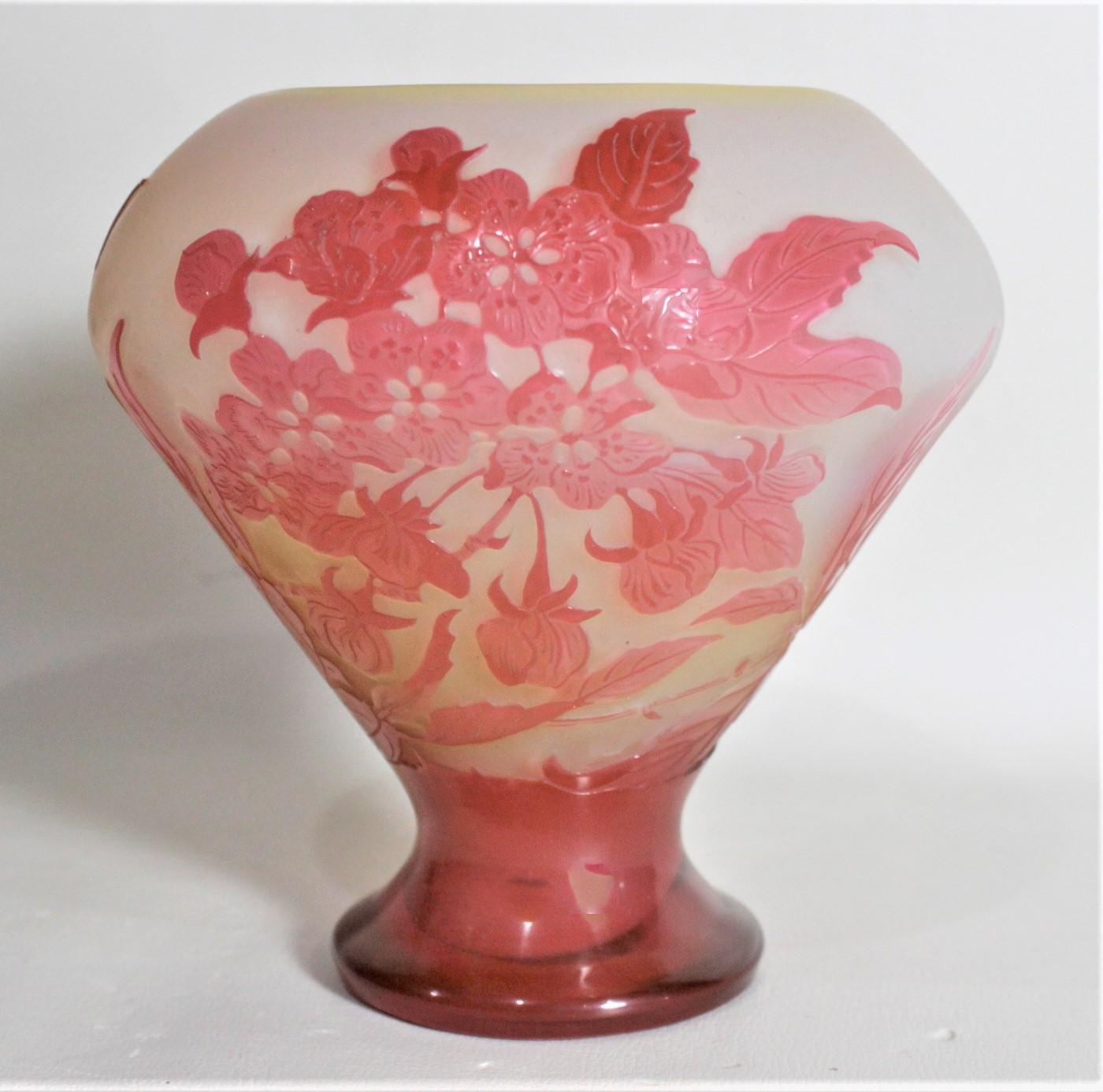 This cameo art glass cabinet vase was made by the highly renowned Emile Galle of France in circa 1905 in the period Art Nouveau style. The vase is done in in a bright yellow ground with a frosted white layer over top, followed bya bright red or