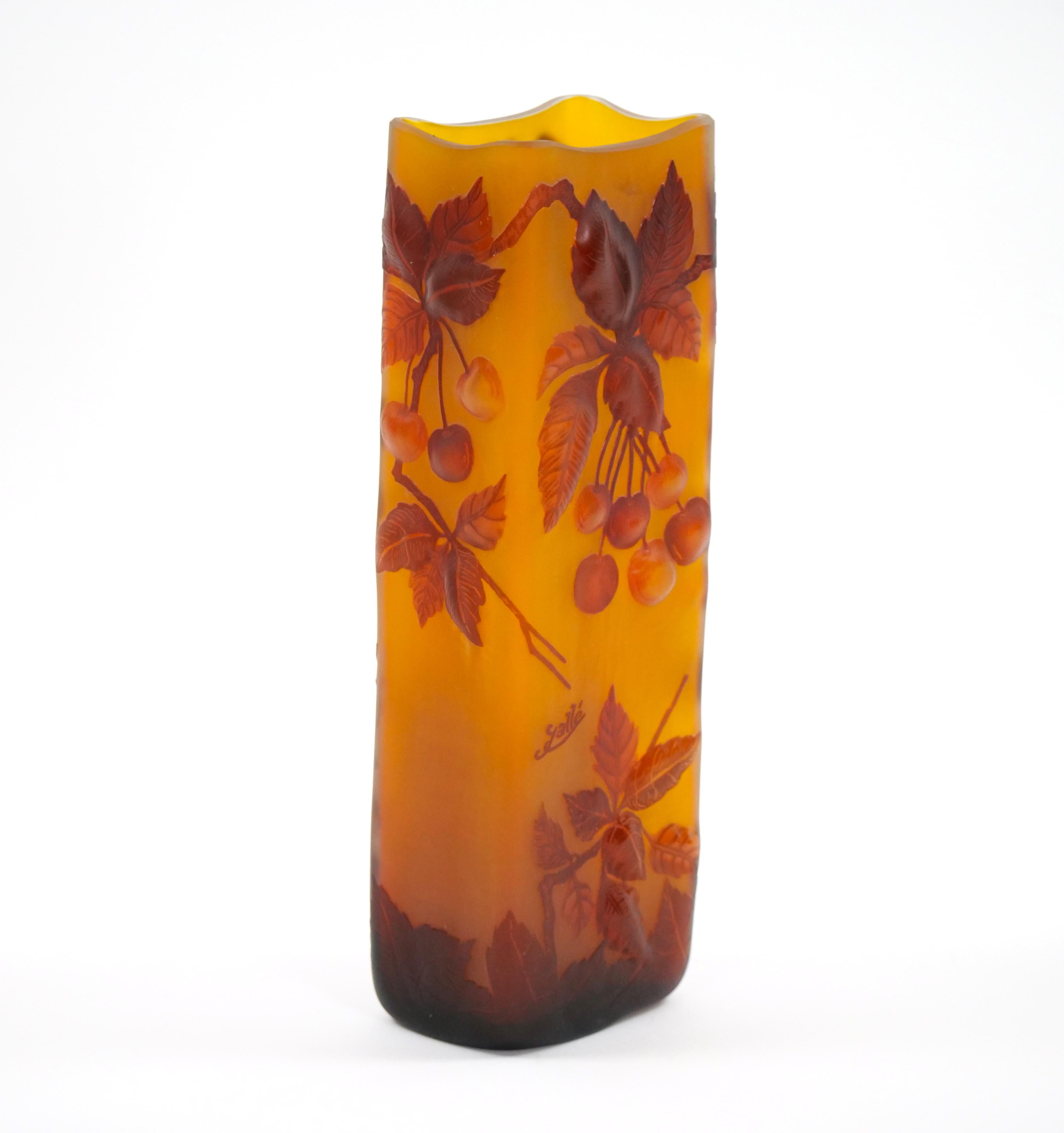Elevate your space with the timeless beauty of an Emile Galle square-shaped cameo glass decorative vase. This masterpiece portrays the graceful imagery of grapes and flowering vines, rendered in rich red hues against a warm amber ground. Emile