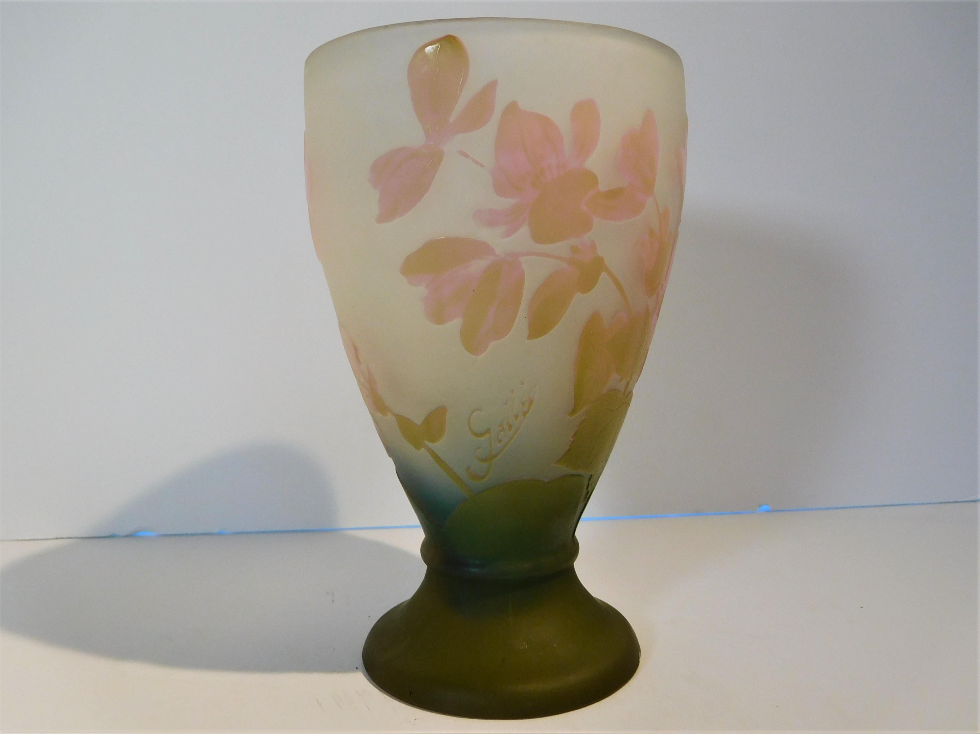 This hand blown, double-overlay and acid-etched vase with leaves and blossoms is in a flaring bulbous form. The base is deep olive green and fades upwards to a rich blue then to a frosty upper body. The leaves are in pale olive green and the
