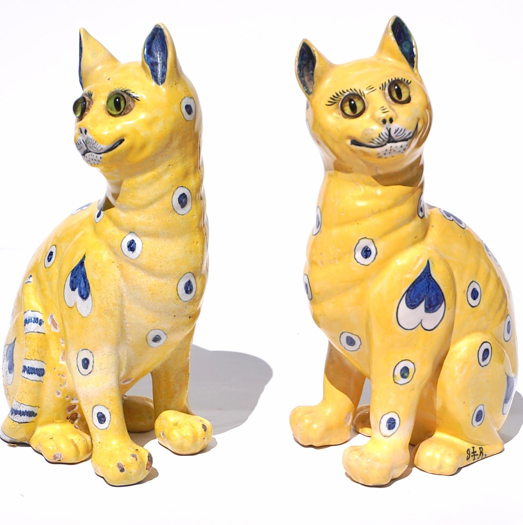 A pair of Emile Galle signed comical whimsical cats with glass eyes made in Nancy France
Circa 1890. Nancy France
Signed on legs with the Gallé Reinemer mark.

The pair of faience yellow ground glazed cats with yellow and green glass eyes created at
