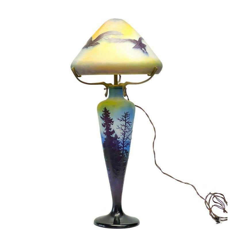 Emile Galle France acid etched 3 layer cameo glass table lamp trees eagles, c1920

Emile Galle France acid etched cameo glass table lamp, circa 1920. 3 layers of blue, purple, and yellow glass lamp, base depicting a mountain scene with trees, lamp