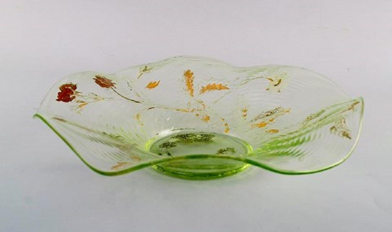 Emile Gallé, France. Antique bowl in mouth-blown art glass with hand-painted flower decorations in gold, 1870s-1880s.
Measures: 24 x 5 cm.
In good condition with minor wear in the gold.
Signed.