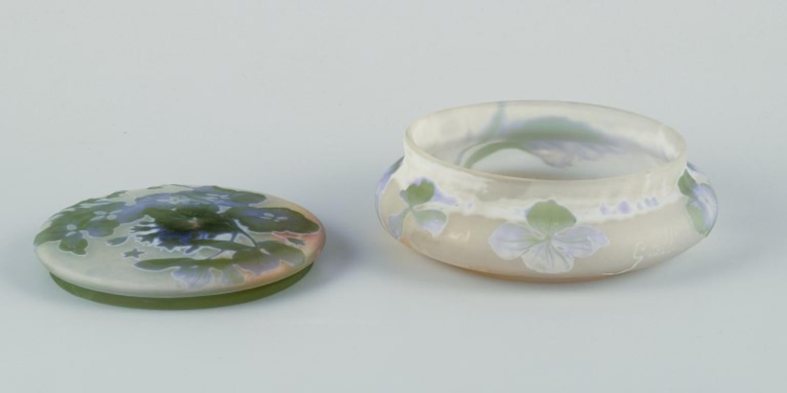 Pre-owned goods are exempt from import duties for U.S. customers. 
Therefore, no import tariffs will be applicable to your purchase.

Emile Gallé, France. 
Rare glass bonbonniere / lidded jar, with violet and green overlay glass. Floral motif.
Art