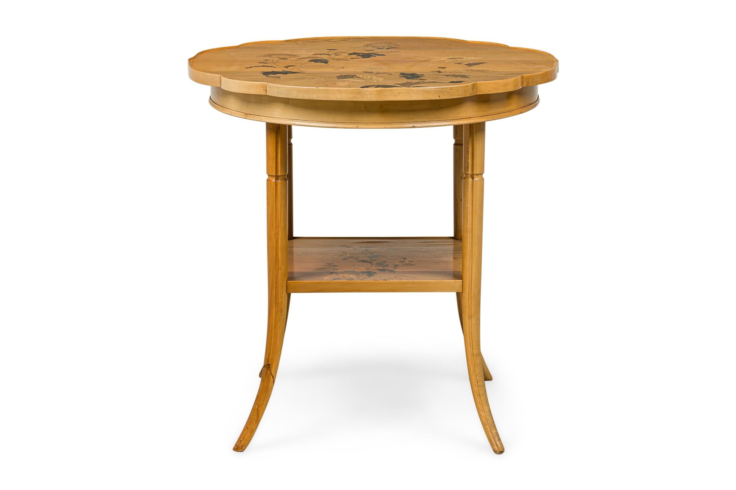 French Art Nouveau occasional table with a circular top with shaped edge and floral marquetry inlay that rotates on a central axis, resting on four tapered sabre legs joined by a square stretcher with floral marquetry inlay. (EMILE GALLE)
 

 Minor