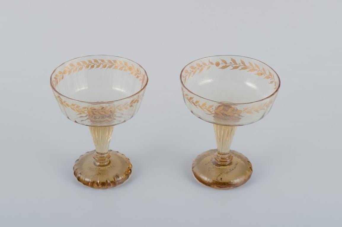 Emile Gallé (1846-1904), French artist and designer.
Two champagne coupes in crystal glass hand-decorated with gold leaf motifs.
1870s/1880s.
Signed: 