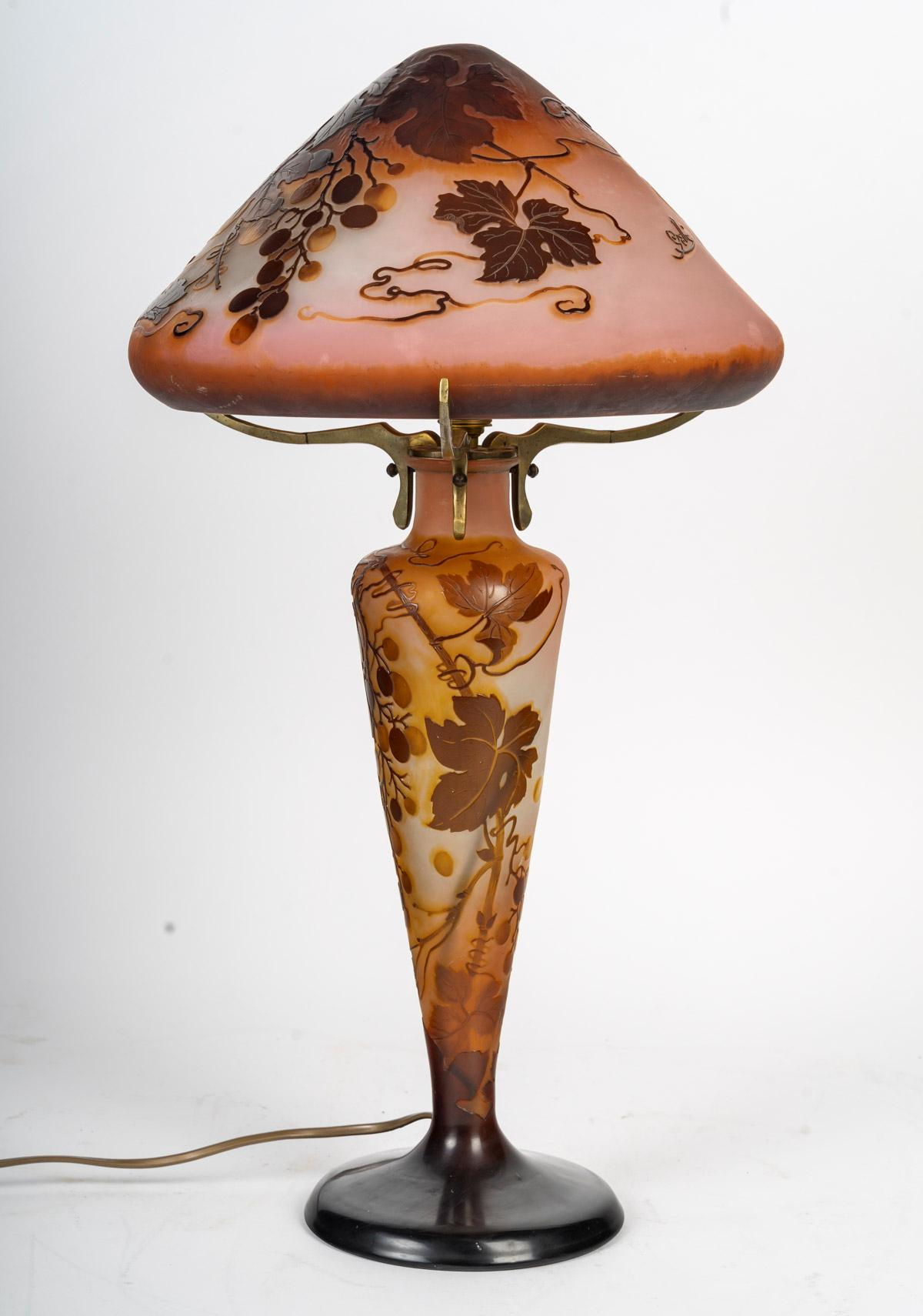 Important mushroom lamp composed of a base and a lampshade in multi-layer acid-etched glass decorated with grapes and vines. The two elements were born together and signed 