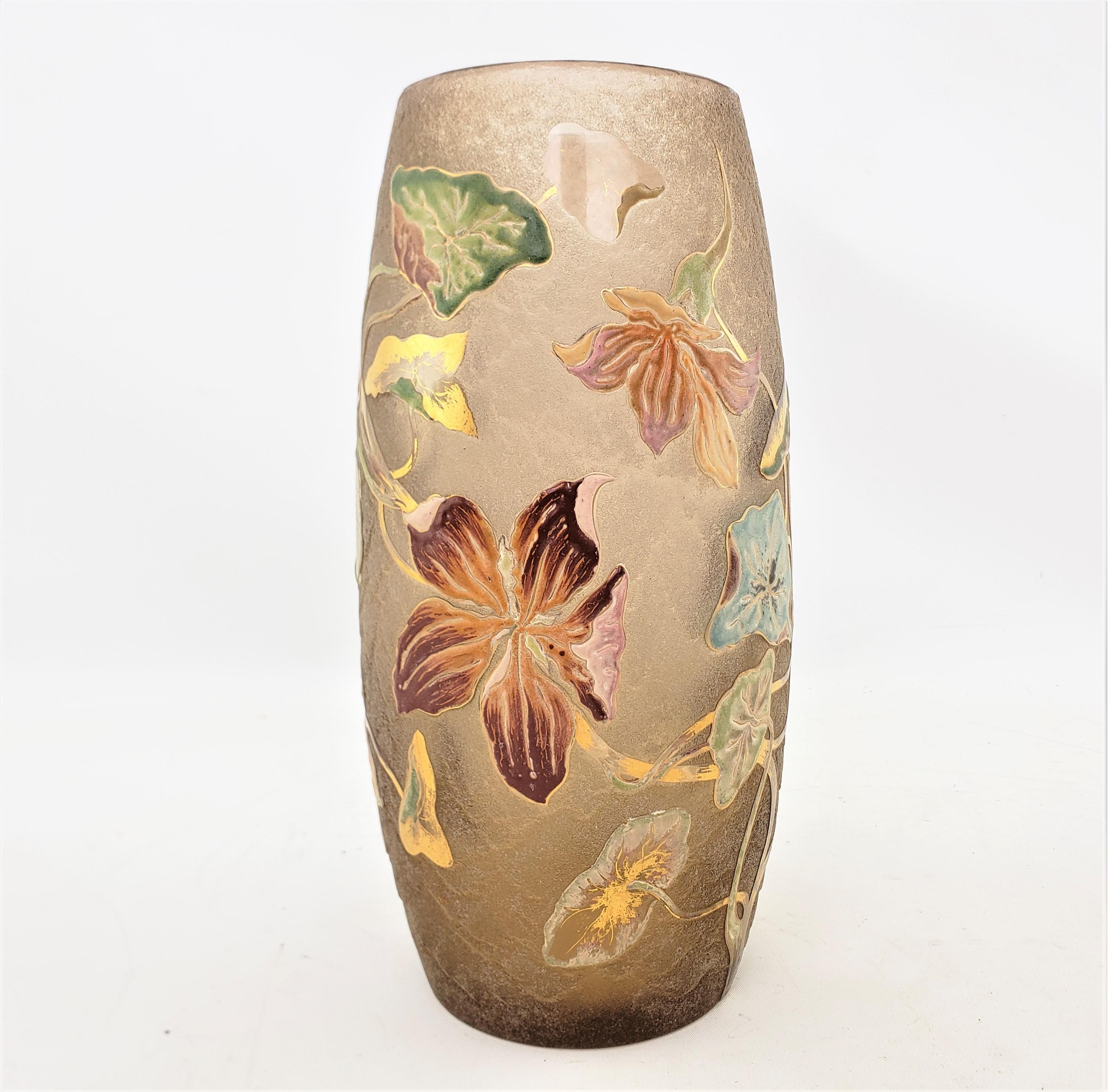 This antique art glass vase was done by the renowned Emile Galle of France in approximately 1900 in the period Art Nouveau style. The vase is done with a deep yellow or amber base and the outside has been acid etched and decorated with enamelled