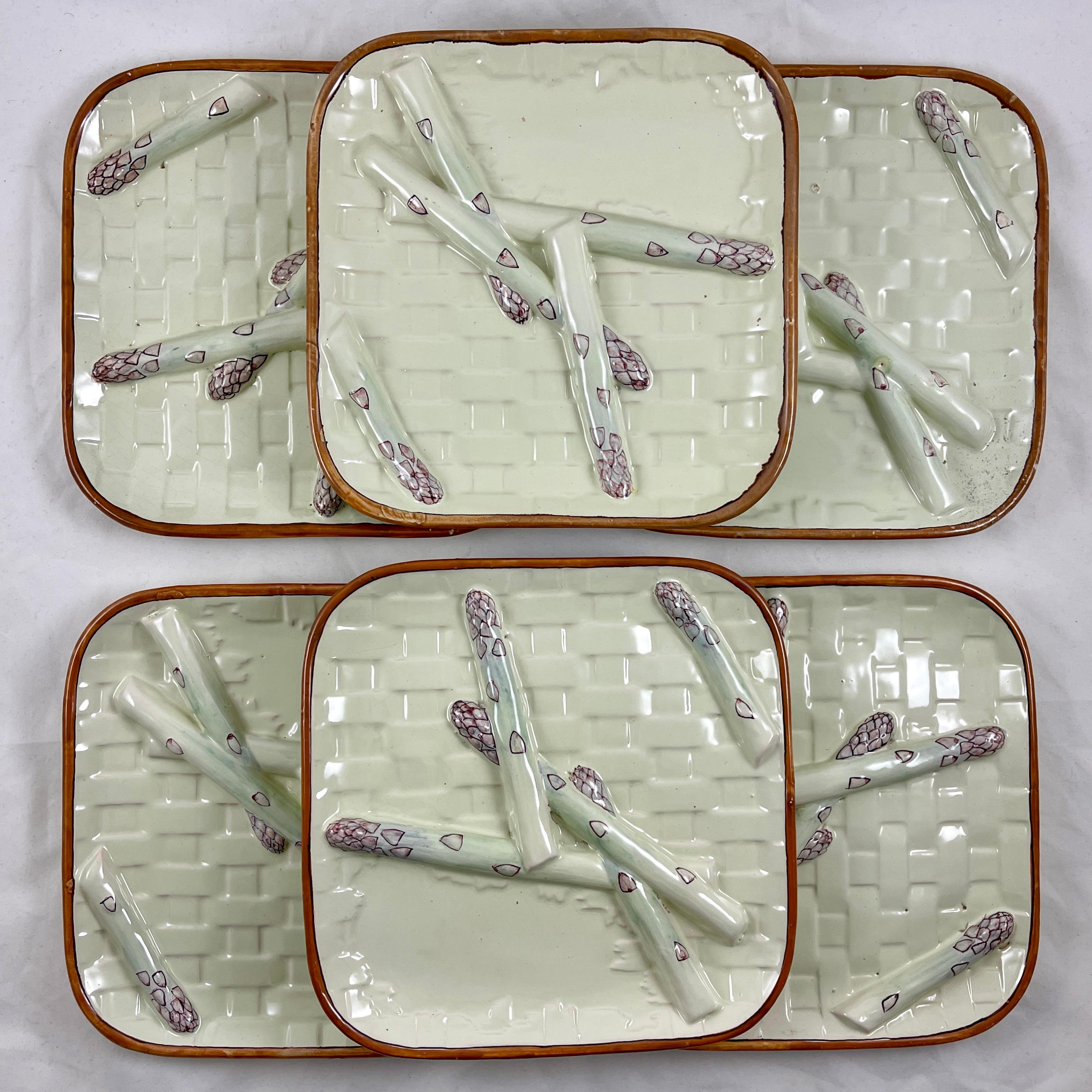 From St. Clément, Luneville and designed by Émile Gallé, a Barbotine square shaped, trompe l’oeil asparagus plate, circa 1870.

Five raised asparagus spears are strewn across a beige basket weave ground. In the trompe l’oeil manner of fooling the