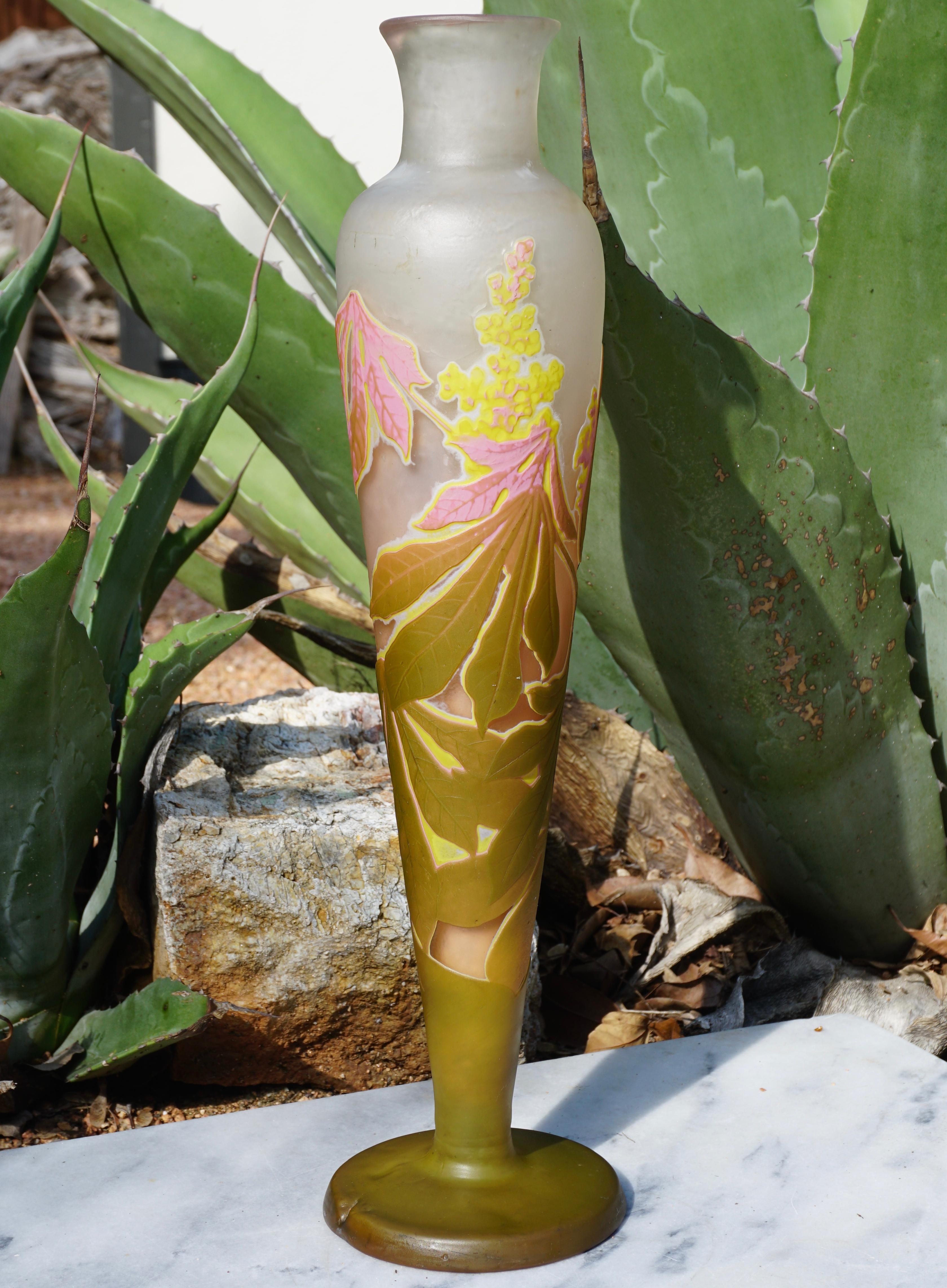 A stunning four color wheel carved and acid etched fat vase with pink, yellow, green and white on a cream background. The coloring is strong and the workmanship excellent. A truly explosive expression of flowering and seeding botanicals. Standing at