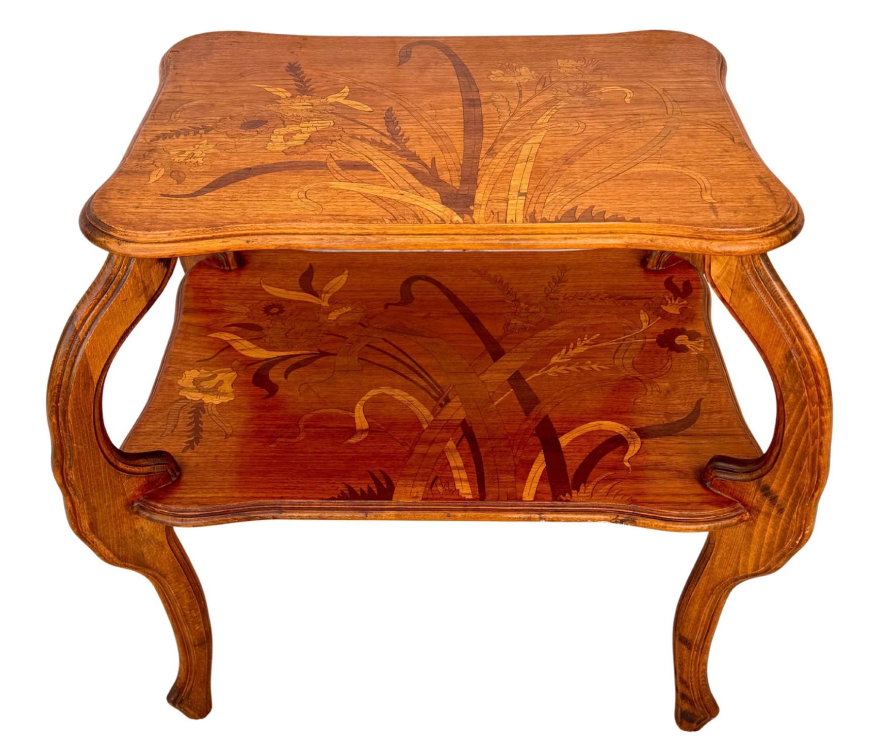 Charming French Two-tiered Marquetry Inlaid Table attributed to Emile Gallè. Table features beautiful inlaid flower motif with leaves and vines with elegant curved legs. Gallè  (1864-1904) was a renowned French artist known for his Art Nouveau style
