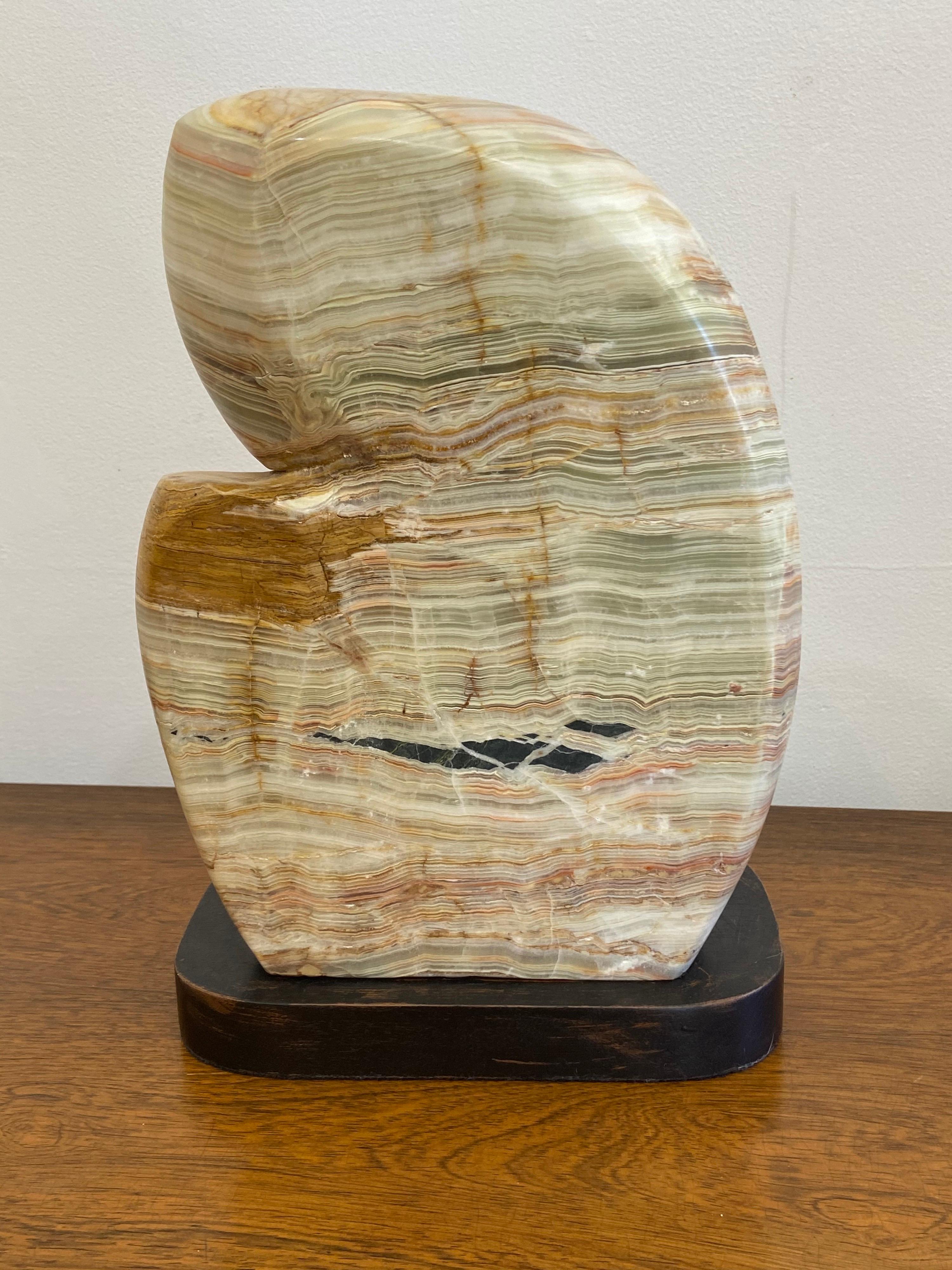 Abstract agate sculpture on wood base.