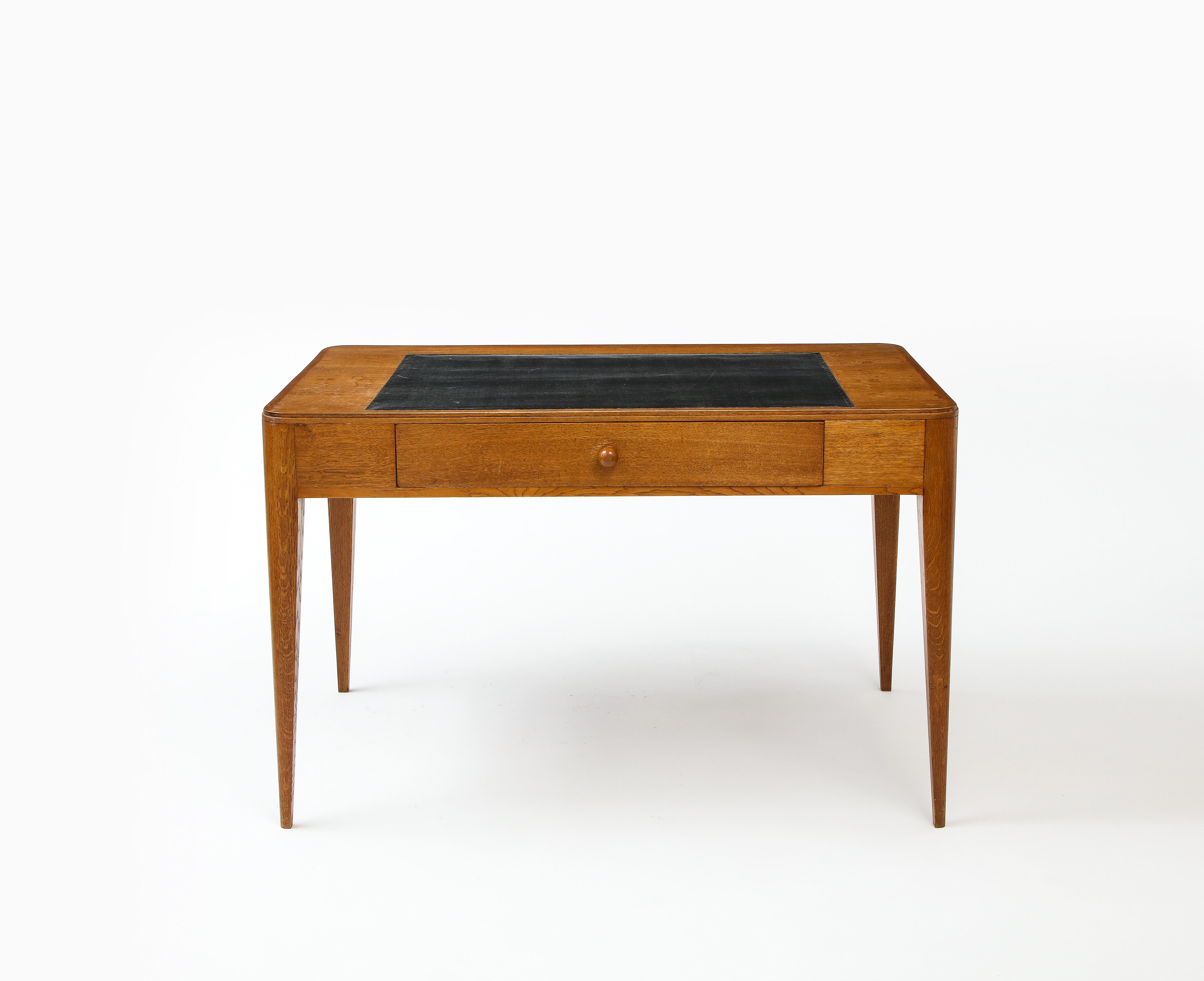 A dévoré oak desk by Émile-Jacques Ruhlmann, with a tan leather top and small drawer to the front.

Provenance : Maison des Provinces de France, cité universitaire, Paris.