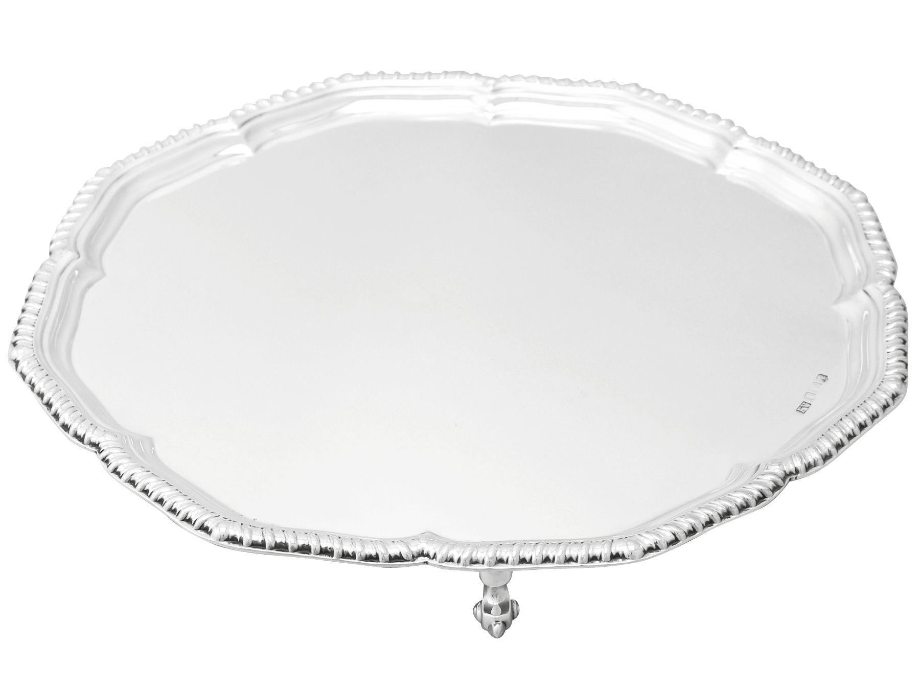A fine and impressive vintage Elizabeth II English sterling silver salver; an addition to our silver dining collection.

This fine vintage Elizabeth II English sterling silver salver has a circular octofoil shaped form onto three feet.

The surface