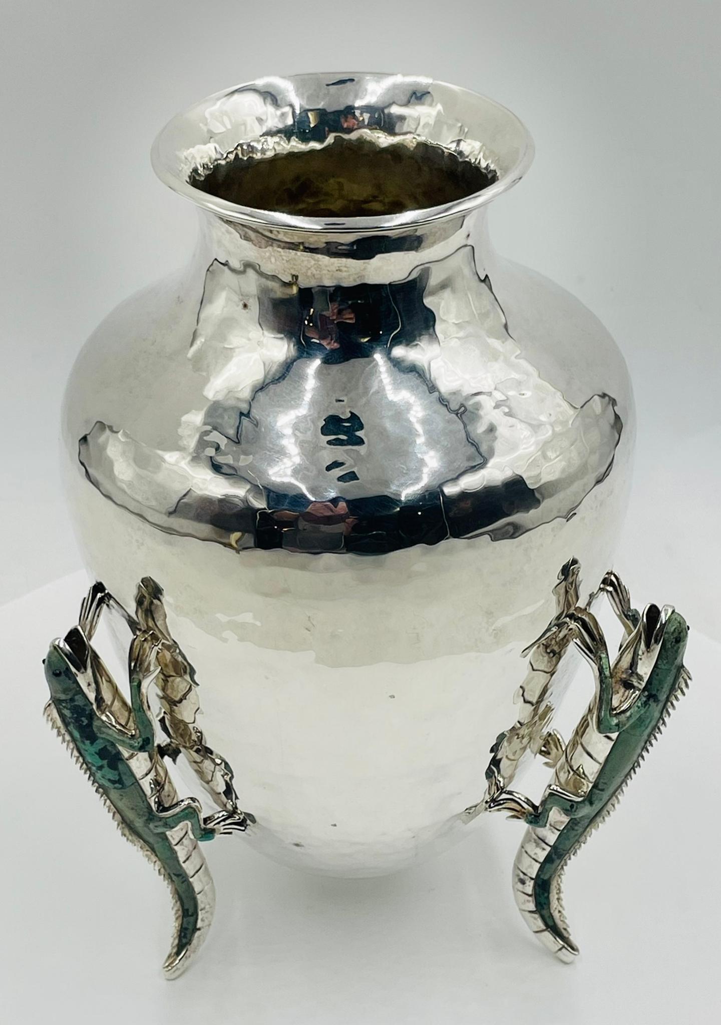Questo vaso d'argento di Emilia Castillo è vivo e pieno di personalità. Tre lucertole d'argento si arrampicano giocosamente sulla sua superficie, con il corpo accentuato da un intarsio di malachite verde intenso che conferisce al pezzo un tocco