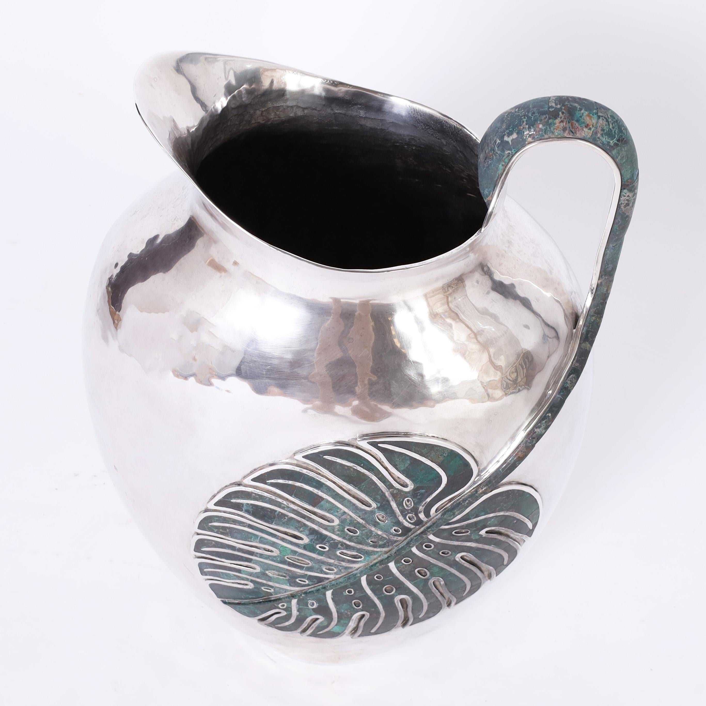 Remarkable vintage pitcher handcrafted with silver plate on hammered copper in a one of a kind object of art featuring a stone philodendron leaf handle. Signed Emilia Castillo on the bottom.