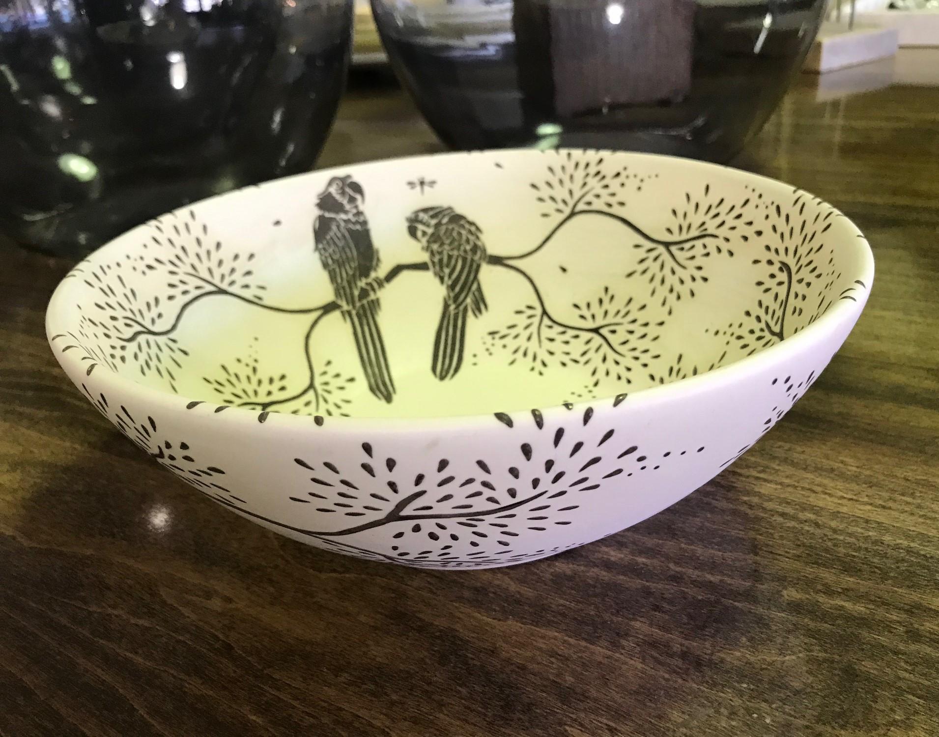 A beautifully designed, one of a kind bowl by famed Taxco, Mexican silver and ceramic artist Emelia Castillo.

The ceramic bowl is cream colored and decorated with sterling silver overlay of parrots and dragonflies on branches with beautiful