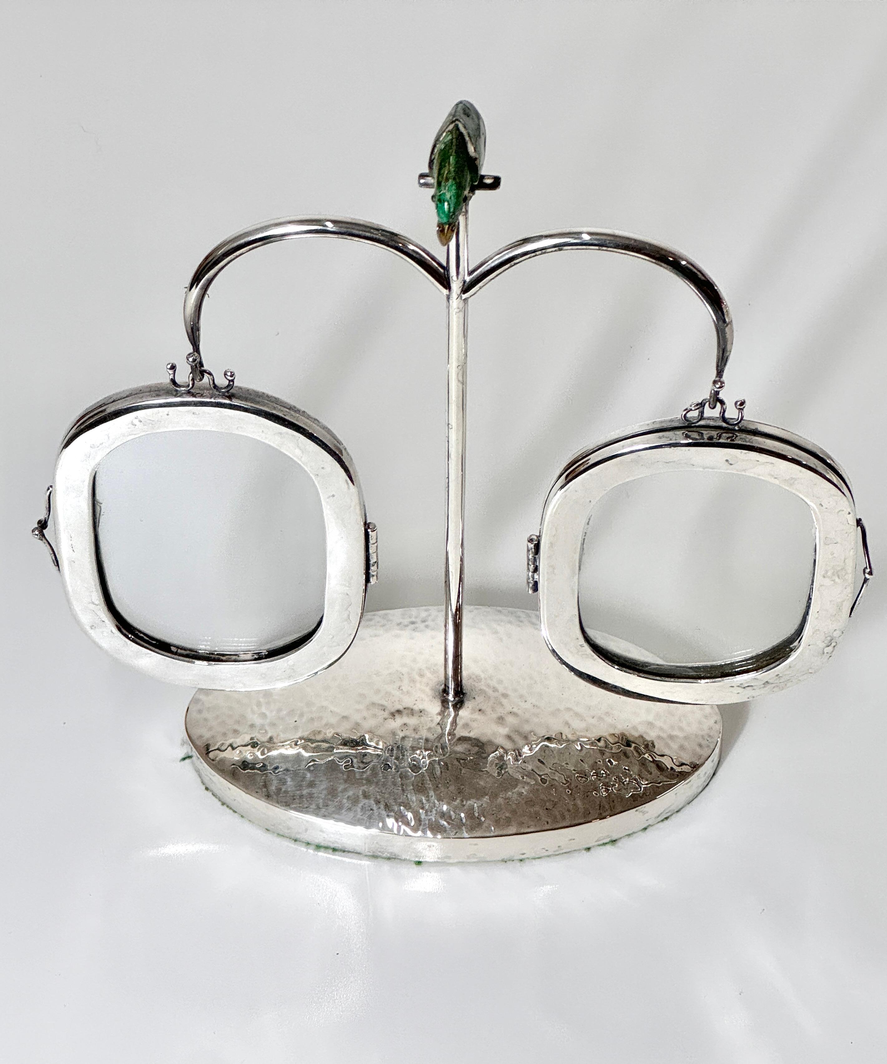 A unique and decorative hanging photo display by Emila Castillo
Mexico circa 1980

Silver plate stand with hammered oval base and a perched parrot made of tessellated turquoise stone and brass
Two hanging picture frames with dual glass panes