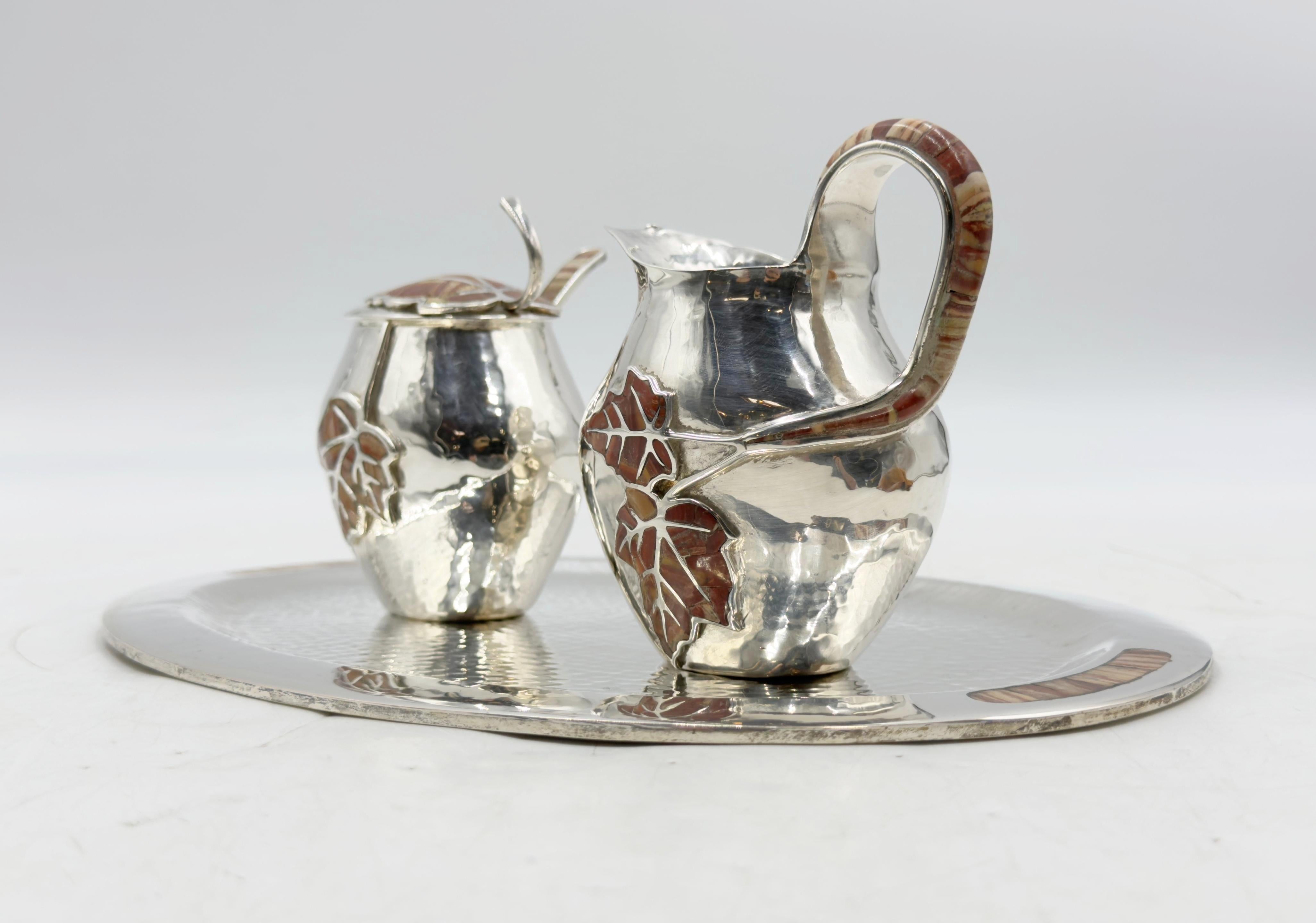 Striking “Maple Leaf” tea service set by acclaimed Mexican designer Emilia Castillo, crafted in solid brass with a silver-plated finish and adorned with hand-inlaid jasper stones forming elegant maple leaf motifs. This signed and hallmarked ensemble