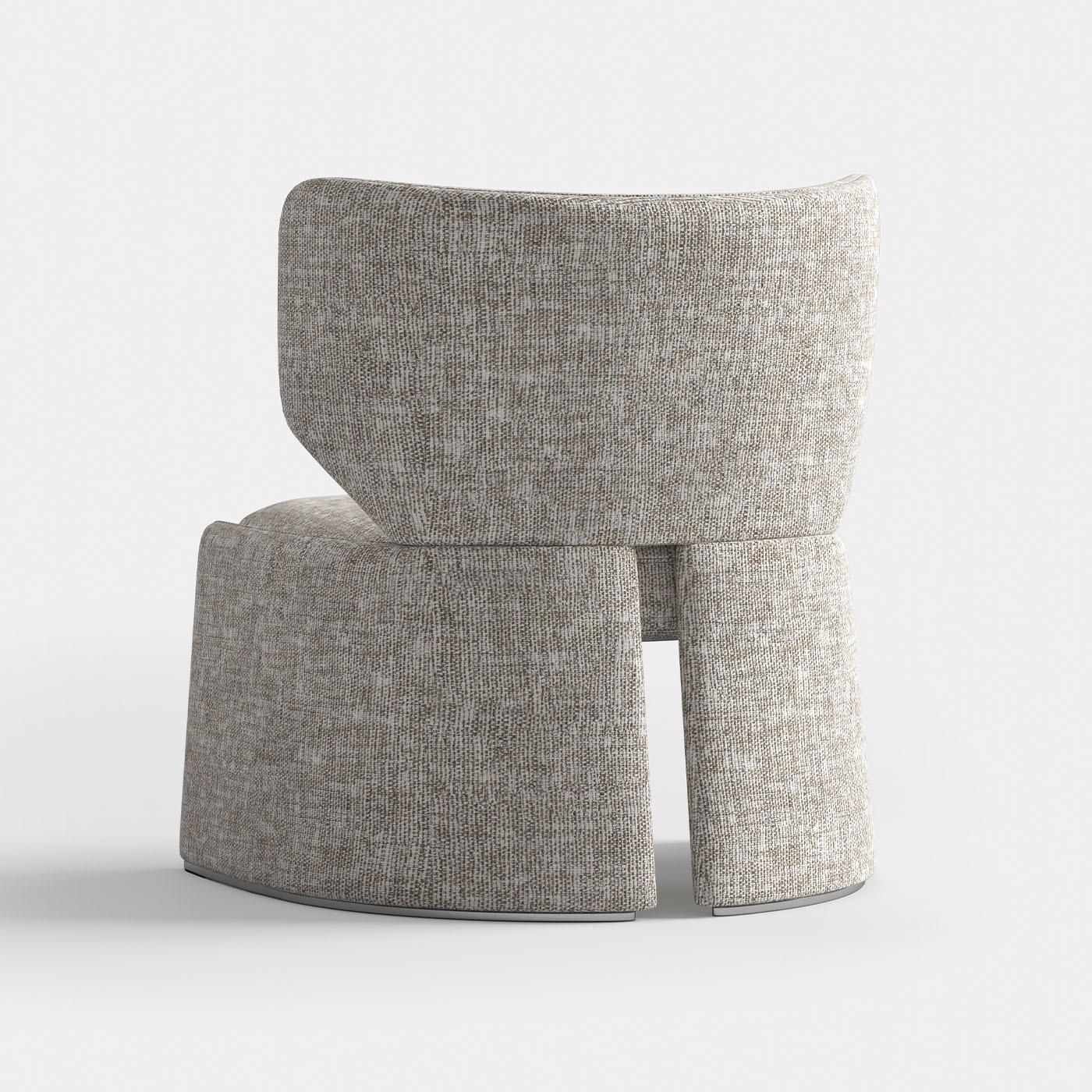 The armchair features a durable metal base and is upholstered in fabric. The design offers a blend of contemporary style and comfort, making it an ideal addition to modern living spaces.