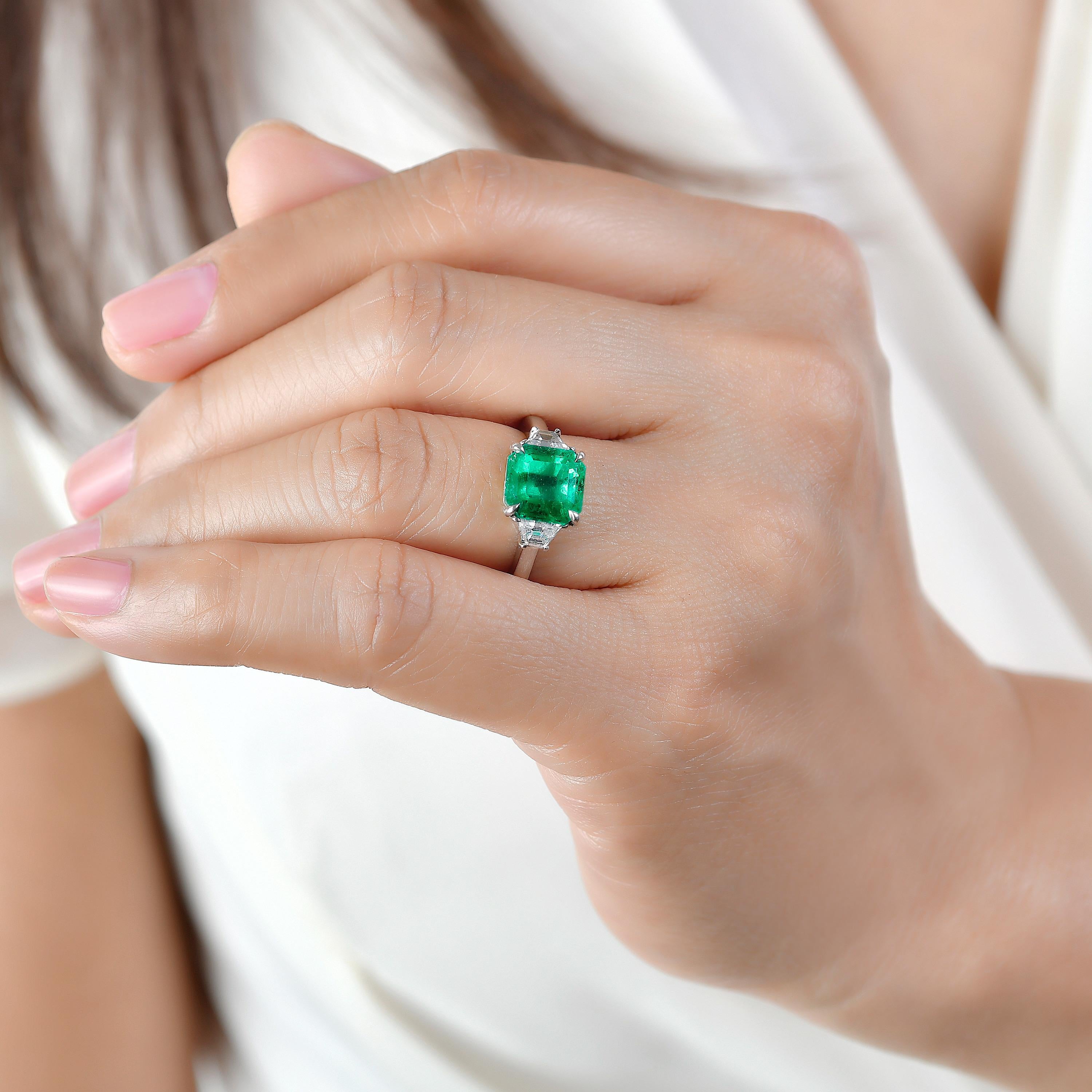 From Emilio Jewelry, a well known and respected wholesaler/dealer located on New York’s iconic Fifth Avenue, 
The focal point of this ring is the 2.92 Carat Vivid Bluish Green Colombian emerald set in the center. This ring is set low and perfect for