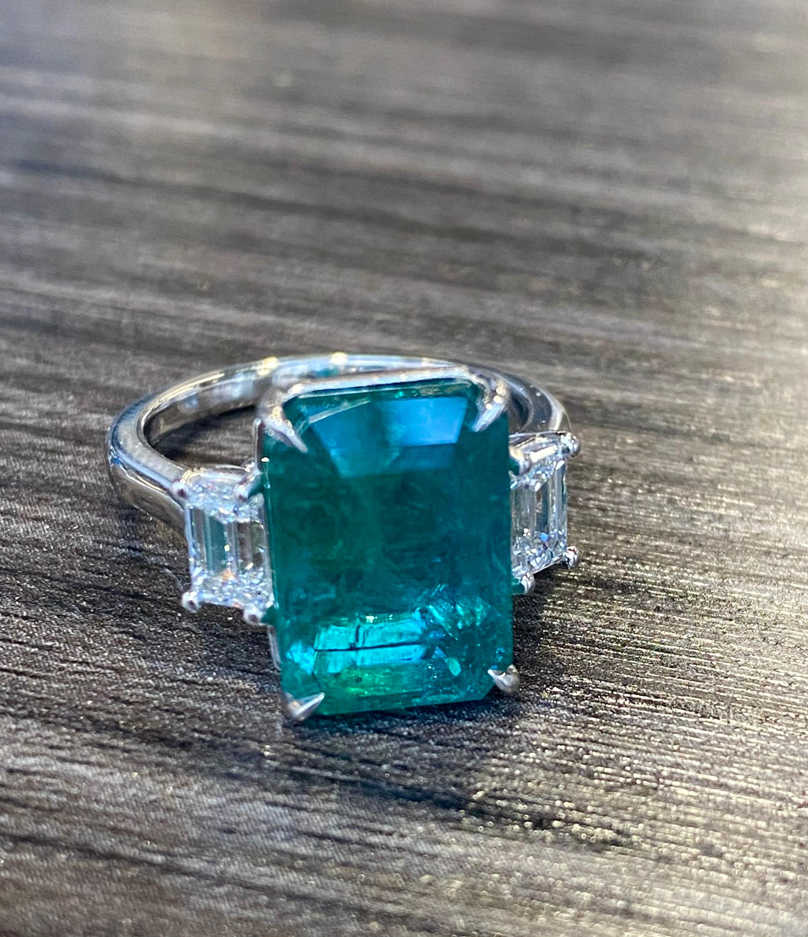 De Emilio Jewelry, un grossiste/revendeur bien connu et respecté situé dans l'emblématique Gem Tower/GIA Building dans le quartier des diamantaires de New York.
Poids total indiqué dans le titre. 
L'émeraude centrale pèse 7,13 ct. 
Monture