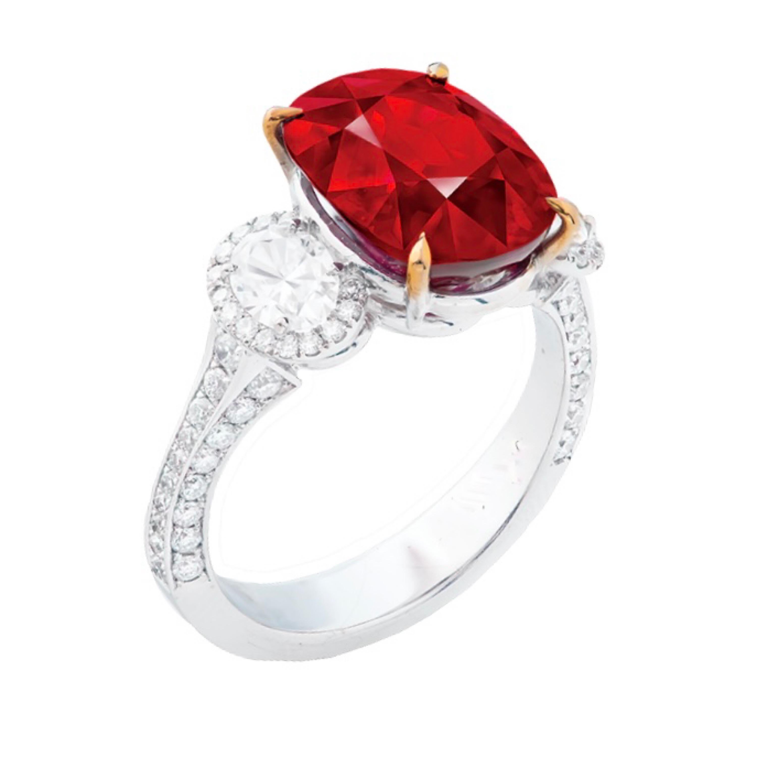 Main stone: 7.03 carats
Color: Vivid Red (PIGEON BLOOD) 
Shape: CUSHION
Setting: 39 white diamonds with a total of about 0.405 carats, 41 white diamonds with a total of about 0.182 carats, 2 fancy oval diamonds with a total of about 0.168