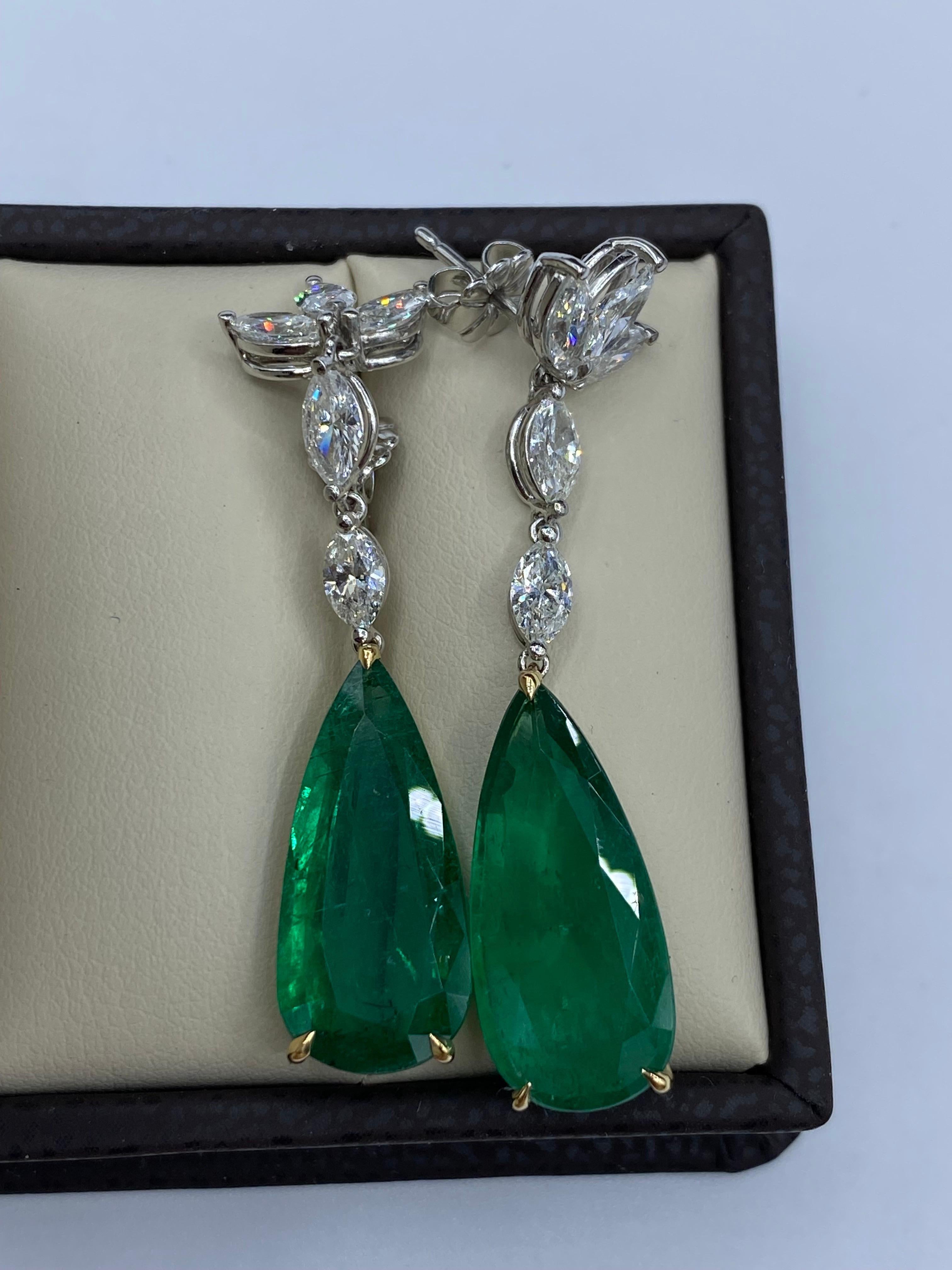 Von Emilio Jewelry, einem bekannten und angesehenen Großhändler mit Sitz auf der berühmten Fifth Avenue in New York, 
2 wunderschöne tropfenförmige Smaragde von insgesamt 12,98 Karat sind der Mittelpunkt dieses Ohrrings. Die Smaragde sind überhaupt