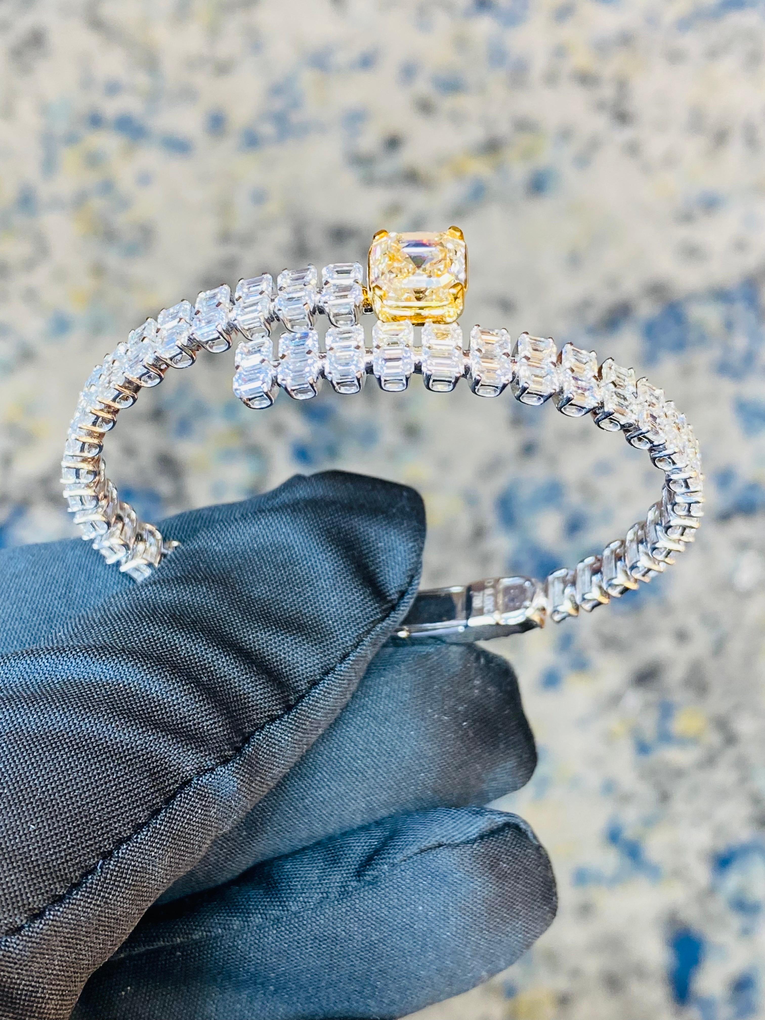From Emilio Jewelry, a well known and respected wholesaler/dealer located on New York’s iconic Fifth Avenue, 
Featuring an Asscher cut 3.00 carat + Yellow Diamond center certified with Gia. An additional array of emerald cut diamonds over 9 carats