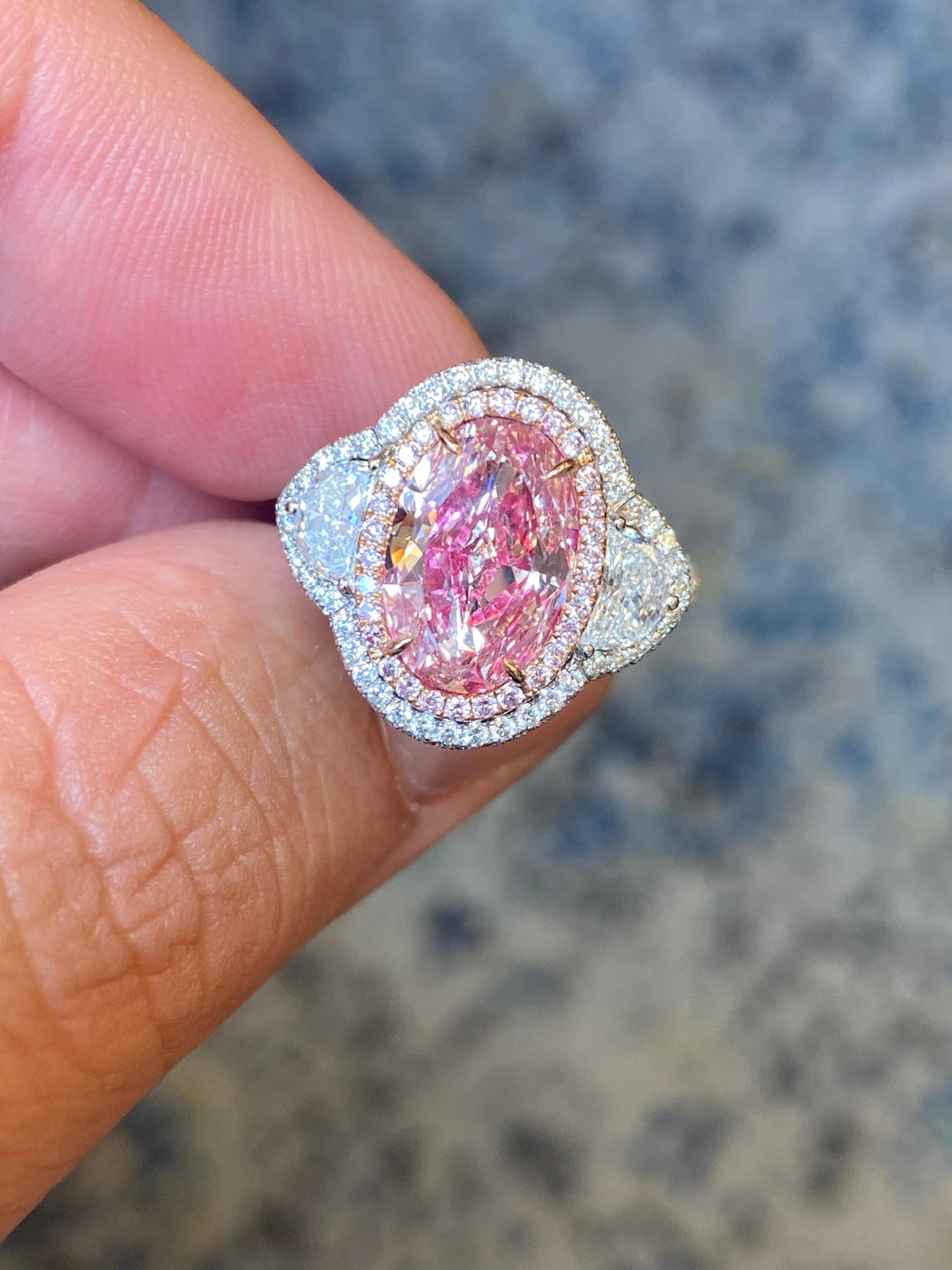 From Emilio Jewelry, a well known and respected wholesaler/dealer located on New York’s iconic Fifth Avenue, 
The focal point of this hand made ring is the excellently layed out Natural Oval Fancy pink diamond weighing just over 3.oo carats. 
We are