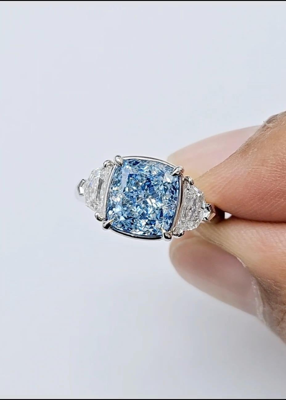 Emilio Jewelry, un grossiste/détaillant bien connu et respecté situé sur l'emblématique Cinquième Avenue de New York, 
Avec un diamant central très spécial certifié GIA comme étant de couleur naturelle bleu fantaisie de 4,00 carats. 
Veuillez vous